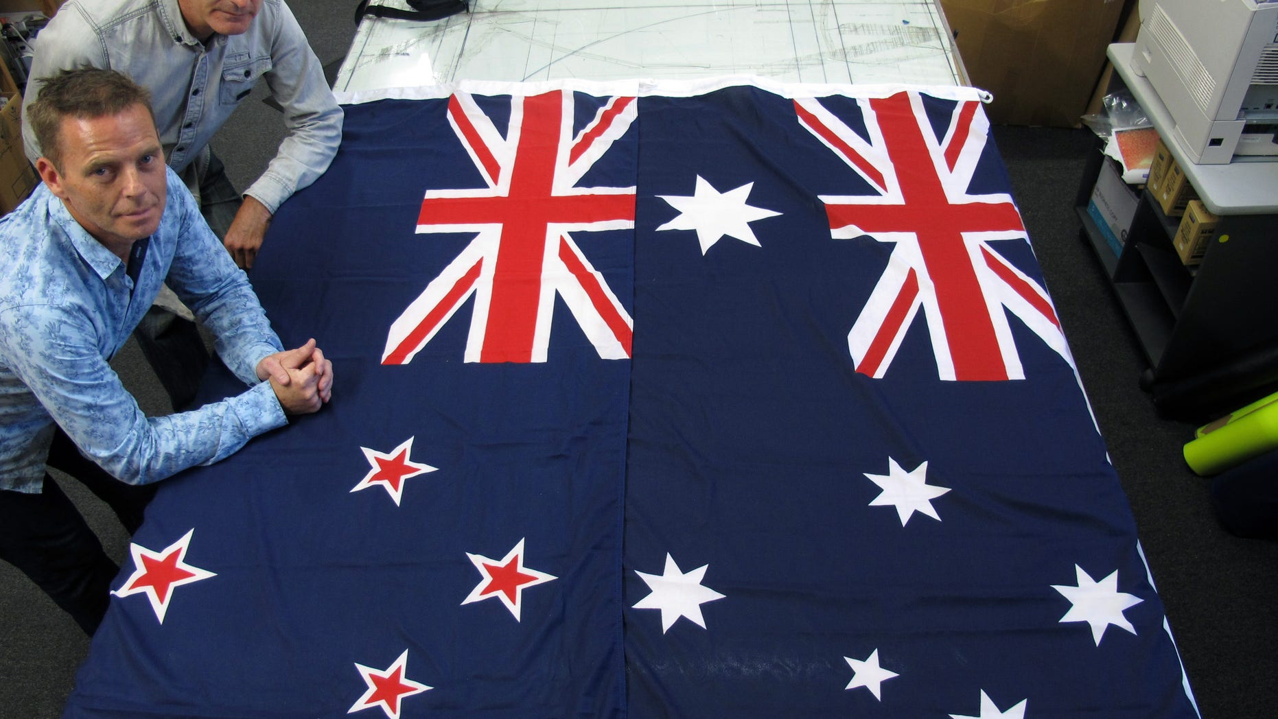 March 3, 2014 - FILE photo of Victor Gizzi, left, and David Moginie, managers at flag manufacturer Flagmakers, next to flags of New Zealand, left, and Australia, in their factory near Wellington, New Zealand. Fresh off a big election win, New Zealand Prime Minster John Key says he wants the nation to vote next year on changing its flag.