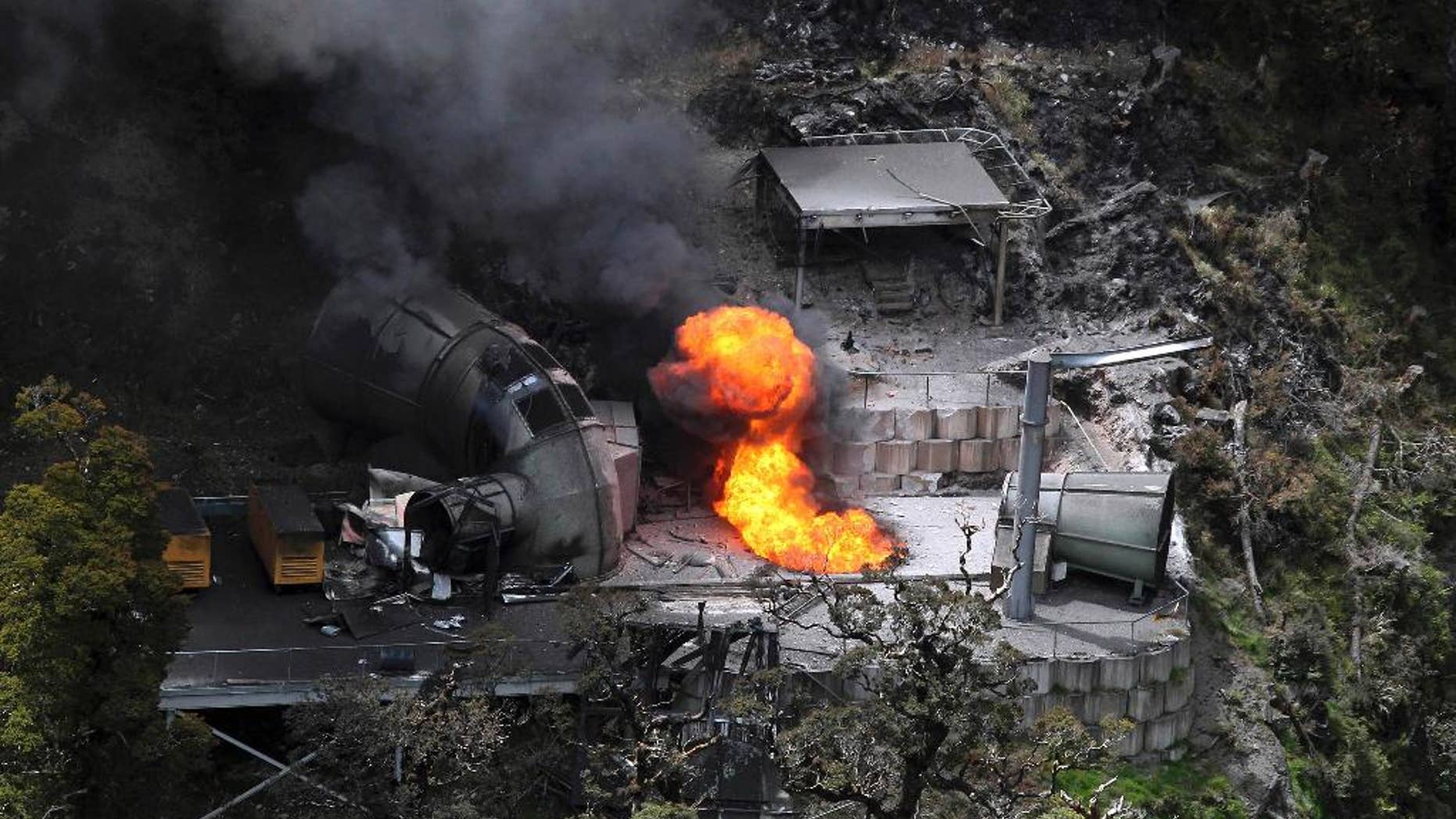FILE - In this Nov. 30, 2010 file photo, flames burn from a ventilation shaft above the Pike River mine which has fatally trapped 29 miners and contractors in Greymouth, New Zealand. The owners of a New Zealand coal mine where the bodies of 29 workers remain entombed after a methane-fueled explosion four years ago said Thursday, Nov. 6, 2014 they won't go back into the mine because it remains too dangerous. (AP Photo/NZPA, Iain McGregor, File) NEW ZEALAND OUT