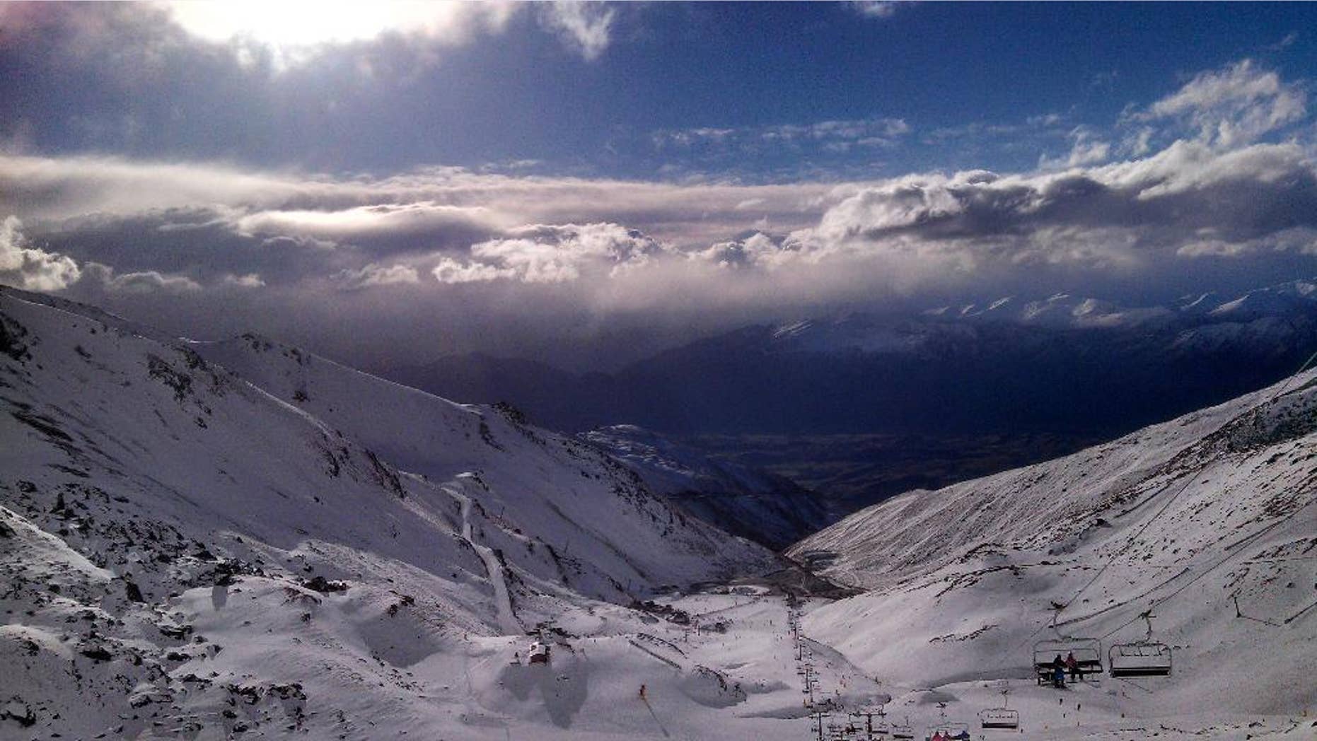 In this Thursday, July 31, 2014 photo, skiers and snowboarders enjoy clear skies at The Remarkables ski area near Queenstown, New Zealand. The Remarkables is one of several large ski areas that has been making snow at record rates following the warmest start to winter ever recorded. Scientists said New Zealand's glaciers and ice are melting at alarming rates due to climate change. (AP Photo/Richard Savoie)