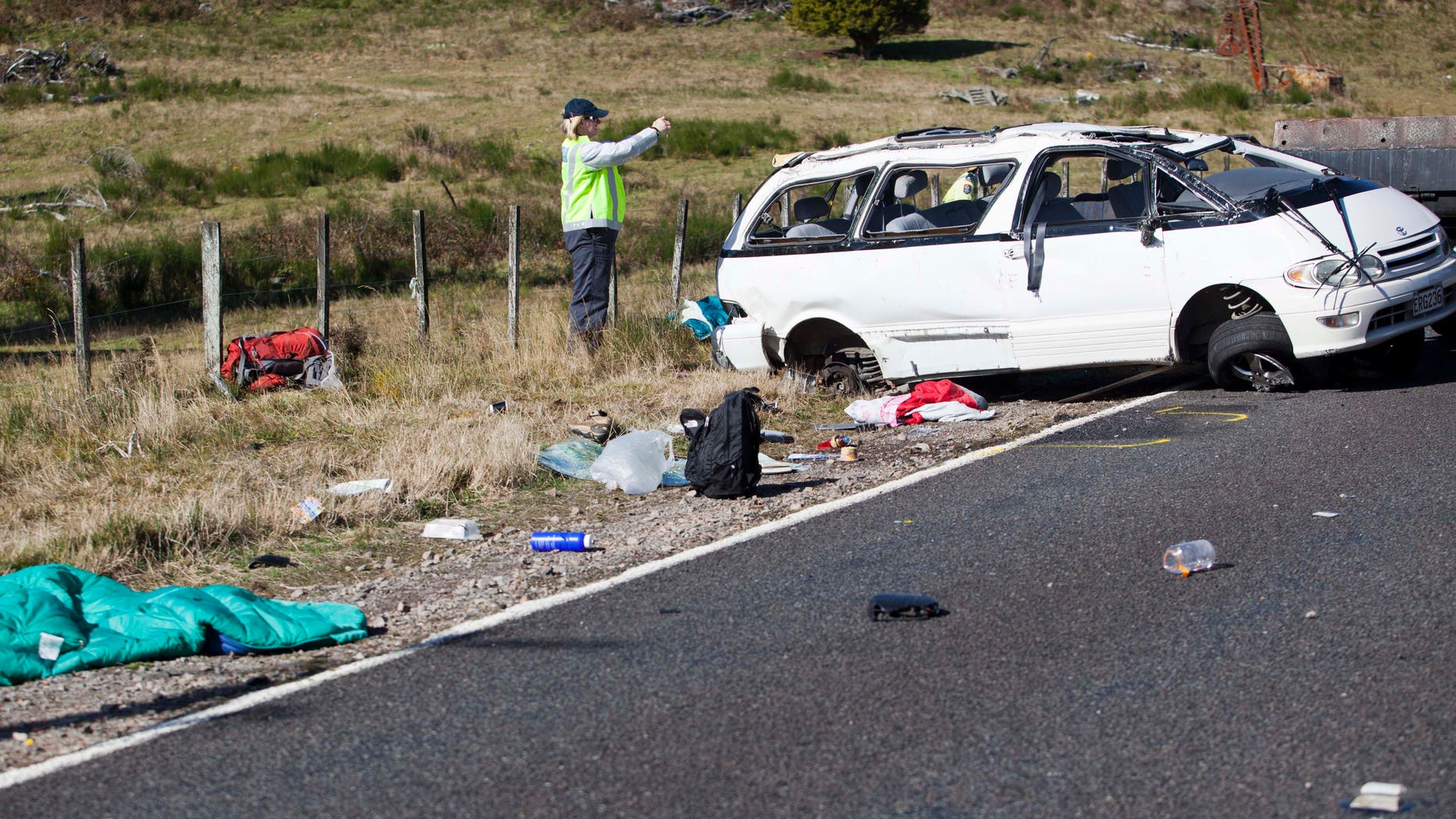 May 12, 2012: Policemen examine the scene of a minivan crash near Turangi, New Zealand, Saturday.