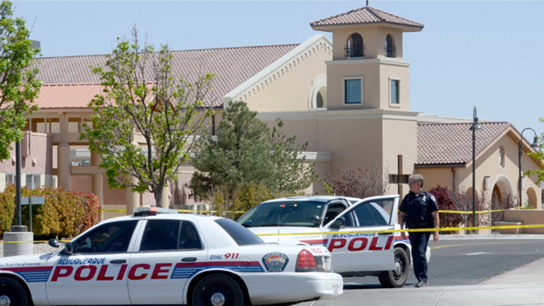 April 28, 2013: An Albuquerque Police officer walks behind the tape at St. Jude Thaddeus Catholic Church.