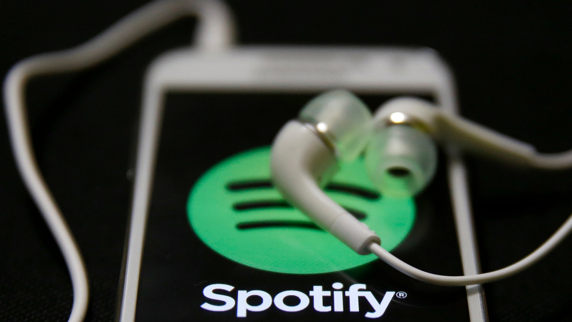 Earphones are seen on top of a smart phone with a Spotify logo on it, in Zenica February 20, 2014. Online music streaming service Spotify is recruiting a U.S. financial reporting specialist, adding to speculation that the Swedish start-up is preparing for a share listing, which one banker said could value the firm at as much as $8 billion (4 billion pounds). REUTERS/Dado Ruvic (BOSNIA AND HERZEGOVINA - Tags: SCIENCE TECHNOLOGY BUSINESS SOCIETY) - RTX1971J