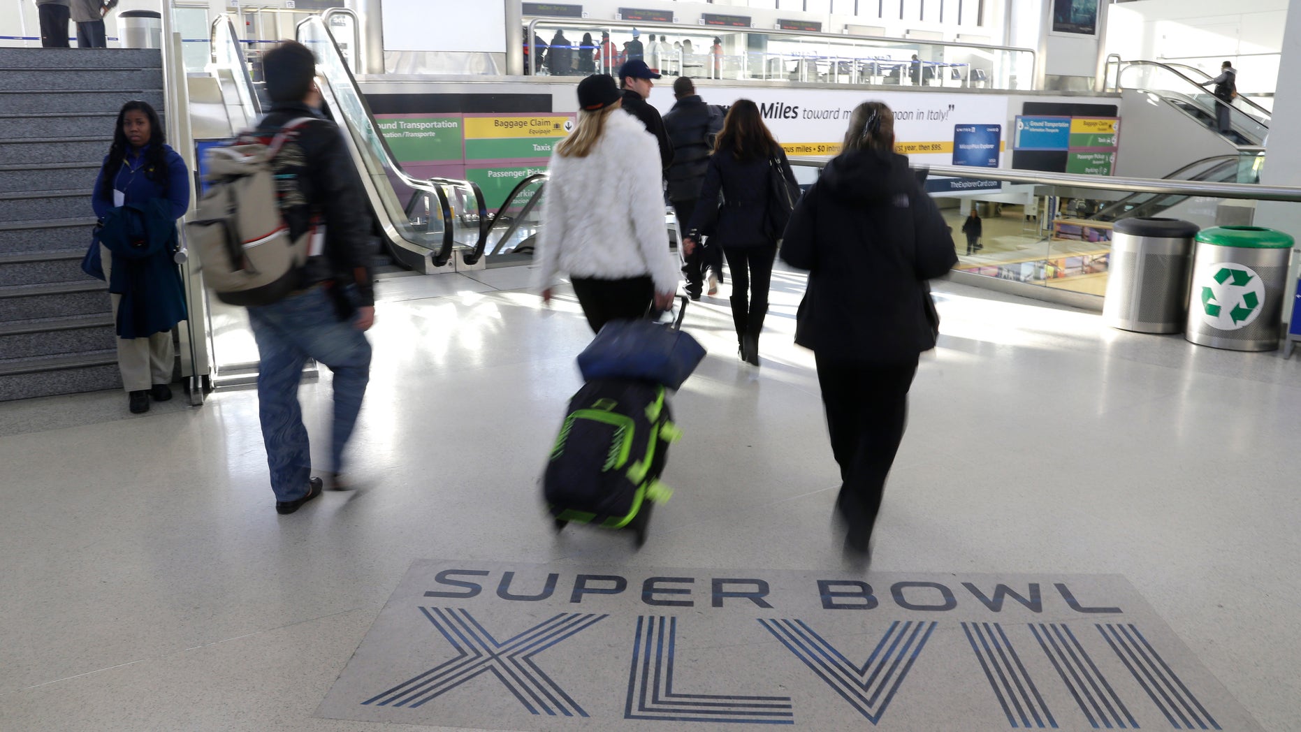 Jan. 30 2014: Arriving passengers walk past a Super Bowl sign at Newark Liberty International Airport in Newark, N.J.