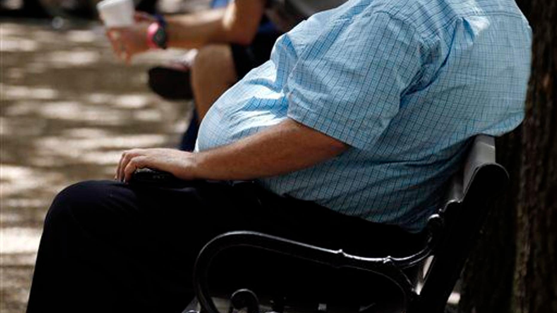 A heavyset man rests on a bench in Jackson, Miss., Sept. 4, 2014.