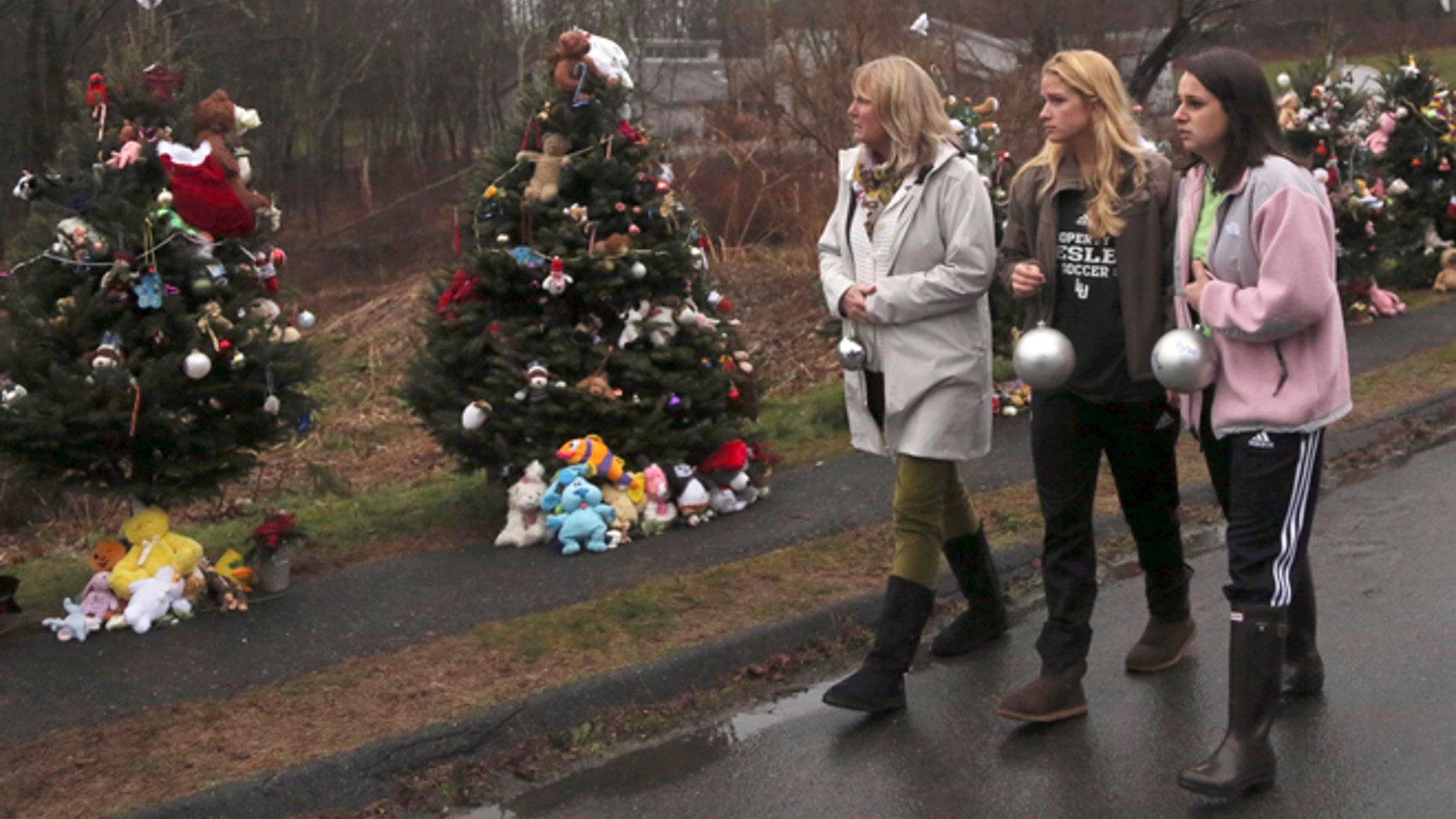 Dec. 17, 2012: Mourners carry ornaments to decorate the Christmas trees at one of the makeshift memorials for the Sandy Hook Elementary School shooting victims, in Newtown, Conn.