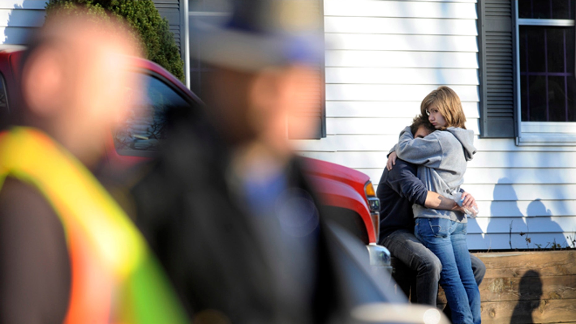 People embrace at a firehouse staging area for family around near the scene of a shooting at the Sandy Hook Elementary School in Newtown, Conn., about 60 miles (96 kilometers) northeast of New York City, Friday, Dec. 14, 2012. An official with knowledge of Friday's shooting said 27 people were dead, including 18 children. (AP Photo/Jessica Hill)