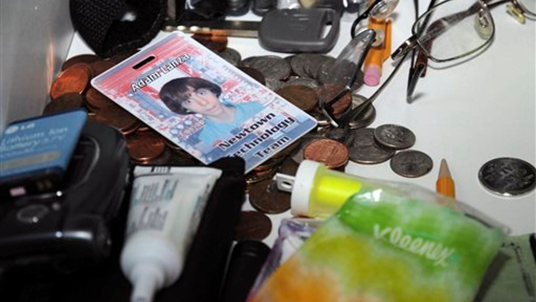 This Dec. 14, 2012 photo released by the Connecticut State Police shows what the evidence report describes as a view of a second floor bathroom and its contents including a photo identification of Adam Lanza and a cellular phone with battery removed, in the house where Adam Lanza lived with his mother in Newtown, Conn. The photo was released as part of the evidence gathered by police during their investigation after Adam Lanza gunned down 20 first-graders and six educators with a semi-automatic rifle at Sandy Hook Elementary School on Dec. 14, 2012, in Newtown. (AP Photo/Connecticut State Police)