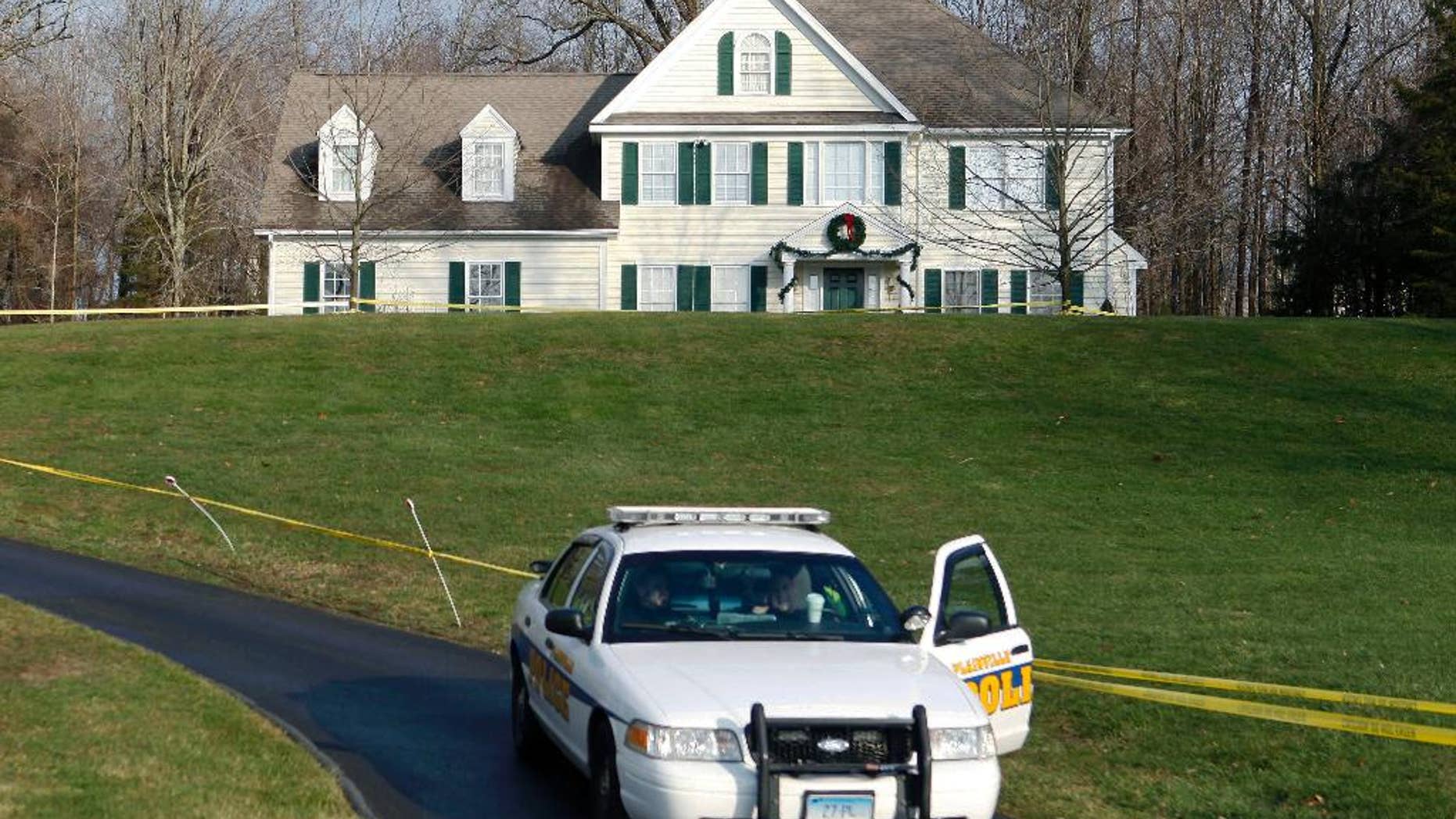 FILE - In this Dec. 18, 2012 file photo a police cruiser sits in the driveway of the home of Nancy Lanza, in Newtown, Conn. The Colonial-style home where Newtown school shooter Adam Lanza lived with his mother has been transferred to the town in a deal with a bank. Nancy Lanza was killed there by her son before he forced his way into Sandy Hook Elementary School, Dec. 14, 2012, in Newtown, where he killed 20 first-graders and six educators. The future use of the house and property will be decided later. (AP Photo/Jason DeCrow, File)