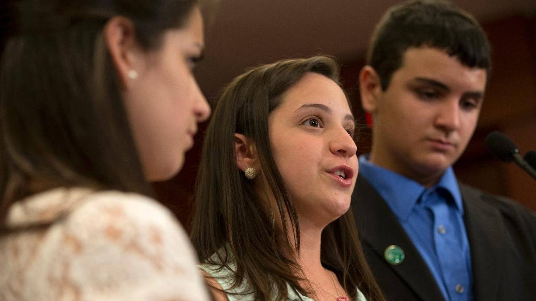 FILE - In a Thursday, June 13, 2013 file photo, Jillian Soto, center, with sister Carlee Soto, left and brother Carlos Soto, the siblings of Victoria Soto, speaks during a news conference on Capitol Hill in Washington, on the sixth month anniversary of the Newtown, Conn. shootings. The family of Victoria Soto, who was killed in the Sandy Hook school massacre, has applied to trademark her name in an attempt to stop others from misusing it on social media. (AP Photo/Jacquelyn Martin, File)