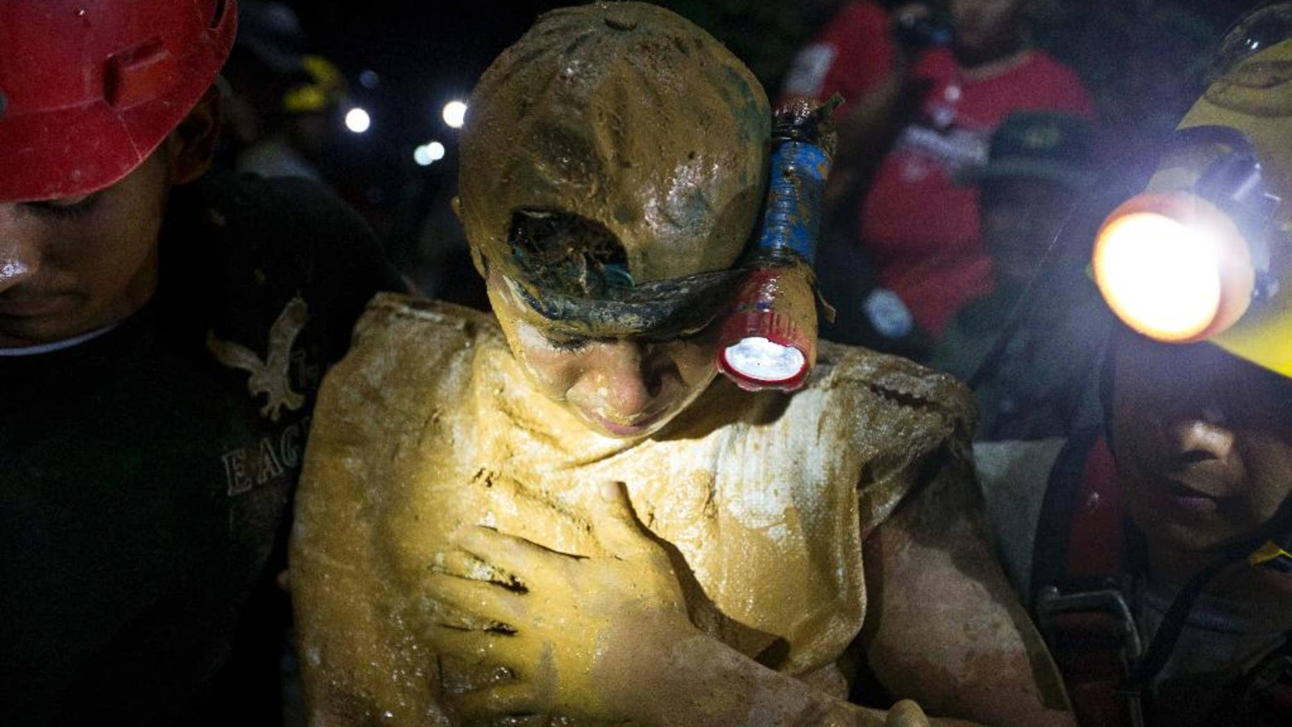 A rescued miner looks down as he leaves the El Comal gold and silver mine after being rescued in Bonanza, Nicaragua, Friday, Aug. 29, 2014. The first 11 of 24 freelance gold miners trapped by a collapse in a mine have been rescued and crews were working early Saturday to free more, officials said. (AP Photo/Esteban Felix)
