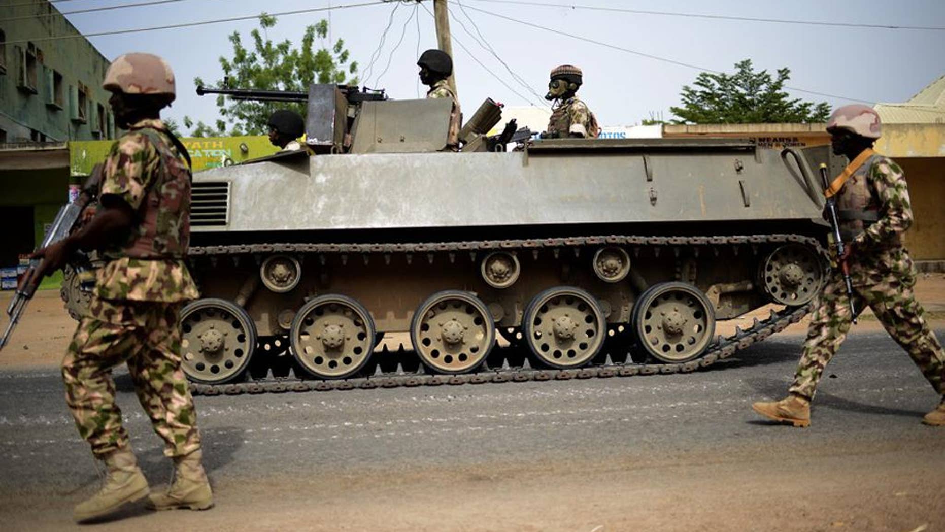 In this photo taken Monday March 9, 2015, Nigerian troops patrol in the north-eastern Nigeria city of Mubi, some 20 kms (14 miles) west of the Cameroon border. Nigerian troops recaptured Mubi from Boko Haram militants in February 2015. On Friday March 13, 2015, the Islamic State group's media arm Al-Furqan, in an audio recording by spokesman Abu Mohammed al-Adnani, said that Boko Haram's pledge of allegiance has been accepted, claiming the caliphate has now expanded to West Africa. (AP Photo/str)
