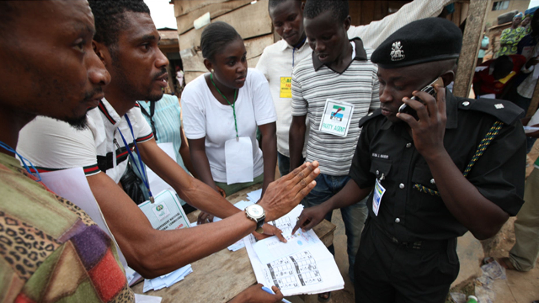 A Police officer, right, checks election results from electoral officers after the National Assembly election in Ibadan, Nigeria,Saturday, April 9, 2011. Nigeria's voters put their inked fingers to ballots Saturday for the first round in the nation's crucial April election, coming out to vote despite bomb attacks and communal violence. Poll workers shoved themselves into rickety commercial buses, cars and other vehicles to travel to the roughly 120,000 polling stations spread throughout Africa's most populous nation. Voting for the nation's estimated 73.5 million voters largely began at noon across the country. (AP Photo/Sunday Alamba)