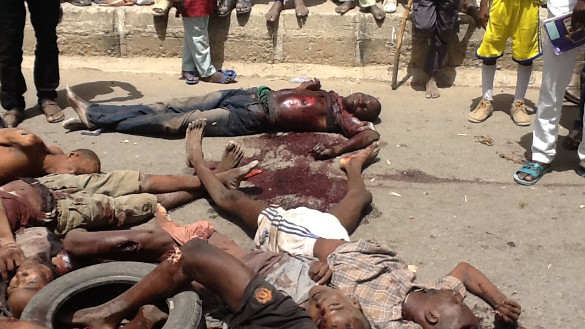 EDITORS NOTE GRAPHIC CONTENT In this Friday, March, 14. 2014 photo released by Amnesty International people gather around bodies of detainees following an attack at Giwa barracks by Islamist militants in Maiduguri, Nigeria. Increasing atrocities by extremists and uncontrolled reprisals by security forces have killed at least 1,500 people this year in northeastern Nigeria's Islamic uprising, Amnesty International reported Monday, March 31, 2014 accusing both sides of war crimes and crimes against humanity . (AP Photo/ Amnesty International)