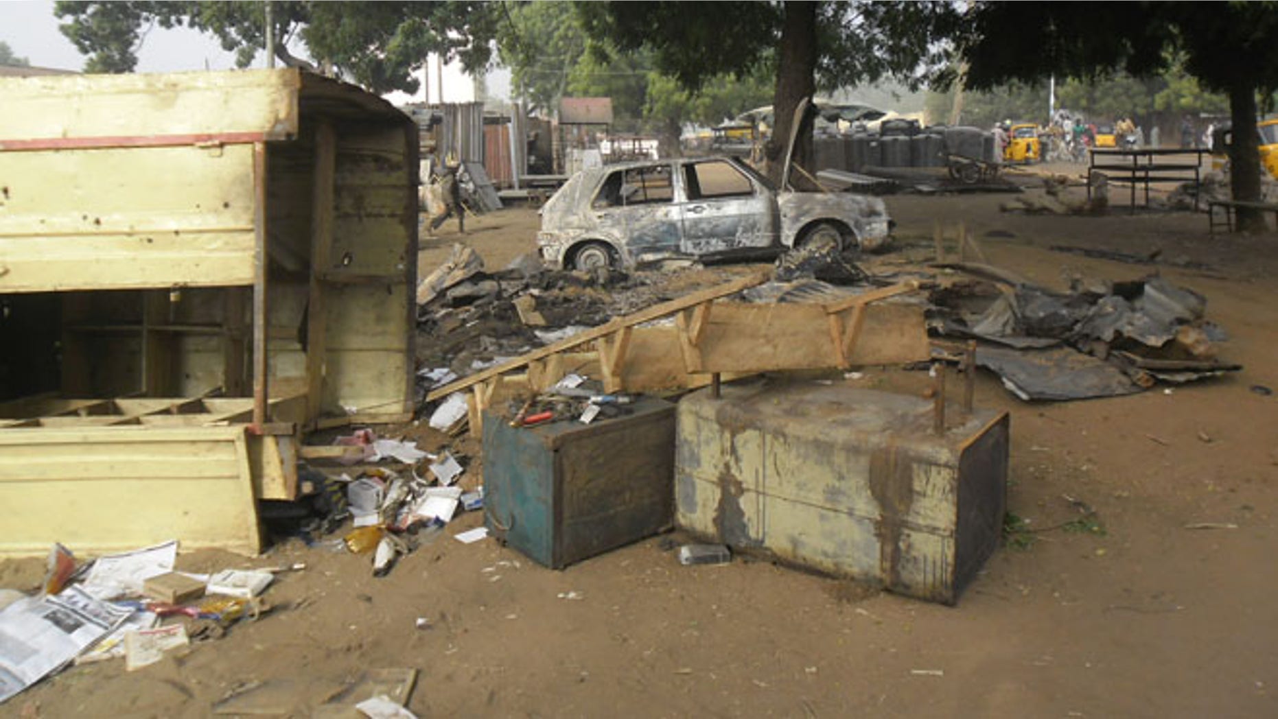 Jan. 12, 2015: A child, at rear, walks through the scene of an explosion in a mobile phone market in Potiskum, Nigeria. (AP)