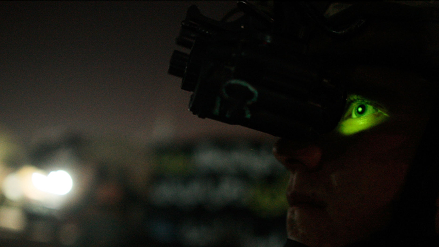 BAGHDAD, IRAQ - JUNE 25: (FRANCE OUT) A paratrooper from the 82nd Airborne Division's 1st Battalion, 325th Infantry Regiment looks through helmet-mounted night vision goggles during a night patrol on June 25, 2007 in the Hurriyah neighborhood of Baghdad, Iraq. The 82nd Airborne conducts night patrols almost every night in the Shia neighborhood in west Baghdad to enforce a 10 pm curfew. (Photo by Chris Hondros/Getty Images)