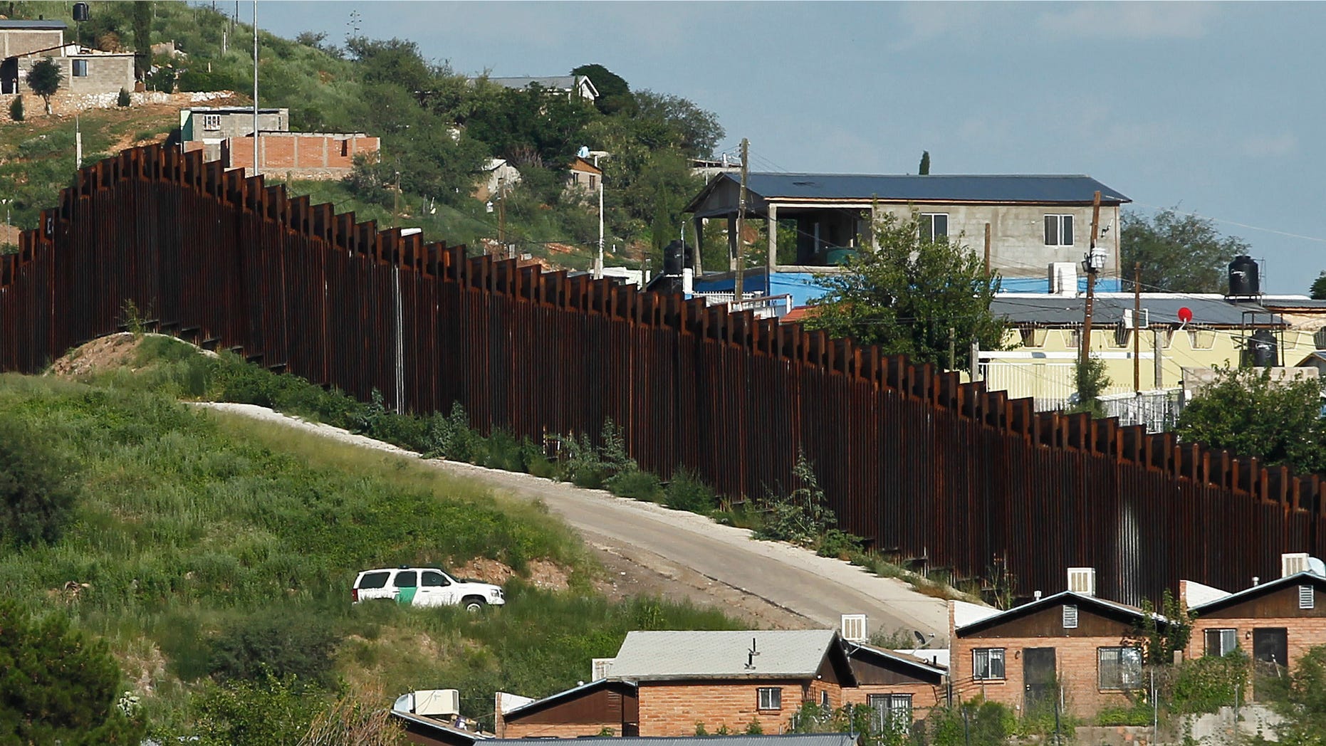 In this photo taken Thursday, Aug. 9, 2012, A U.S. Border Patrol vehicle keeps watch along the border fence in Nogales, Ariz. A U.S. Border Patrol agent opened fire on a group of people throwing rocks from across the Mexican border, killing a teenage boy and eliciting outrage from the Mexican government over the use of lethal force, authorities said Thursday.(AP Photo/Ross D. Franklin)
