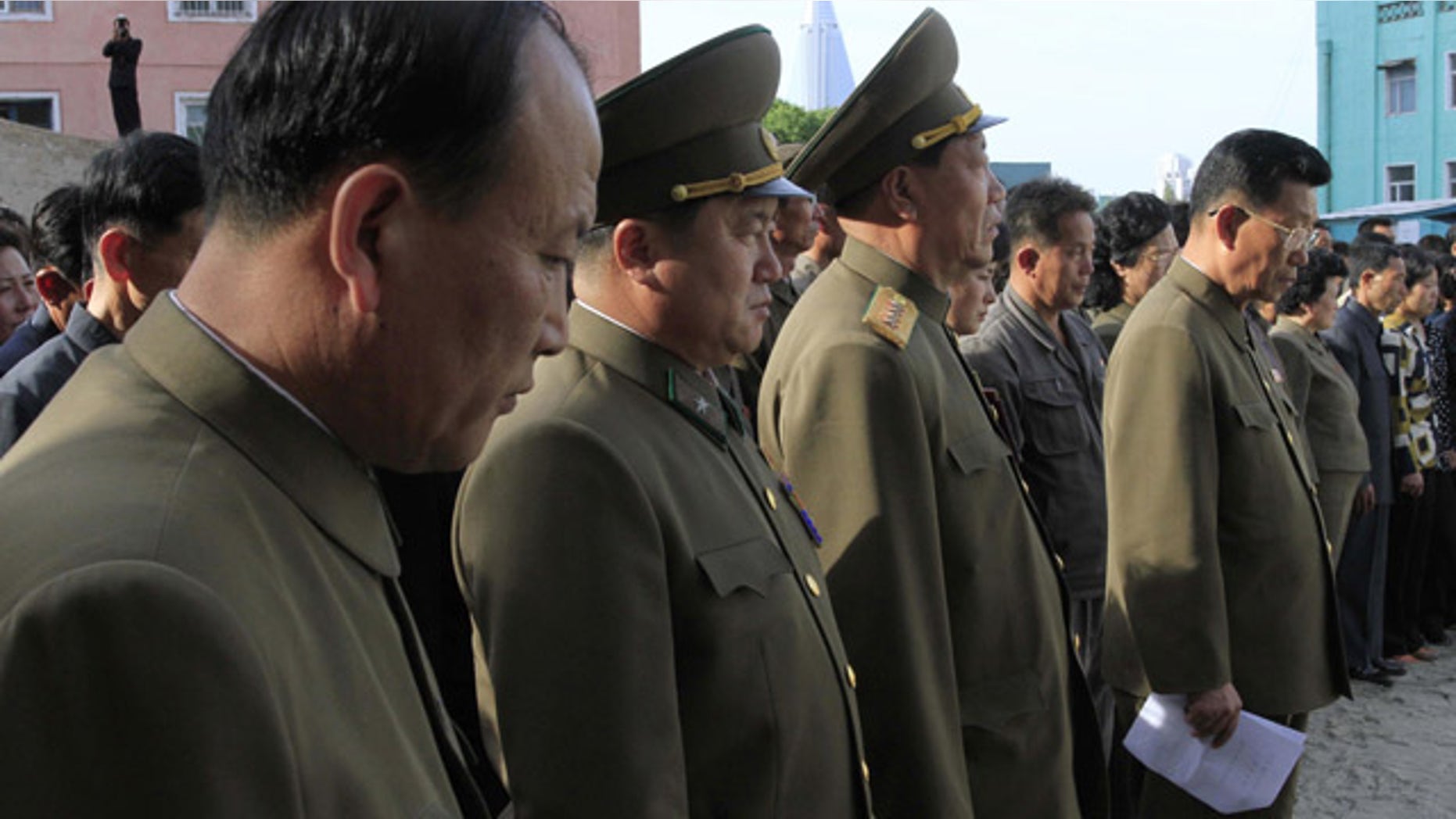 May 17, 2014: North Korean officials stand among the families of victims of an accident at an apartment construction site in Pyongyang, North Korea, during a gathering in the capital where senior officials apologized and took responsibility. (AP Photo/Kim Kwang Hyon)