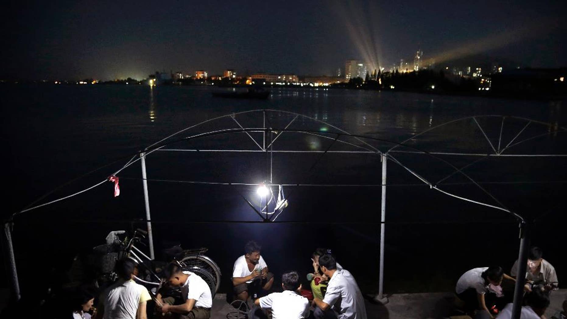 North Koreans cook their dinner over burning charcoal on a pier leading to Jangdok Island, Monday, July 28, 2014 in Wonsan, North Korea. North Korea has been creating special zones across the country to try to boost tourism and Wonsan, long a favorite of North Korean vacationers, is being pushed as a prime destination for international travelers. (AP Photo/Wong Maye-E)