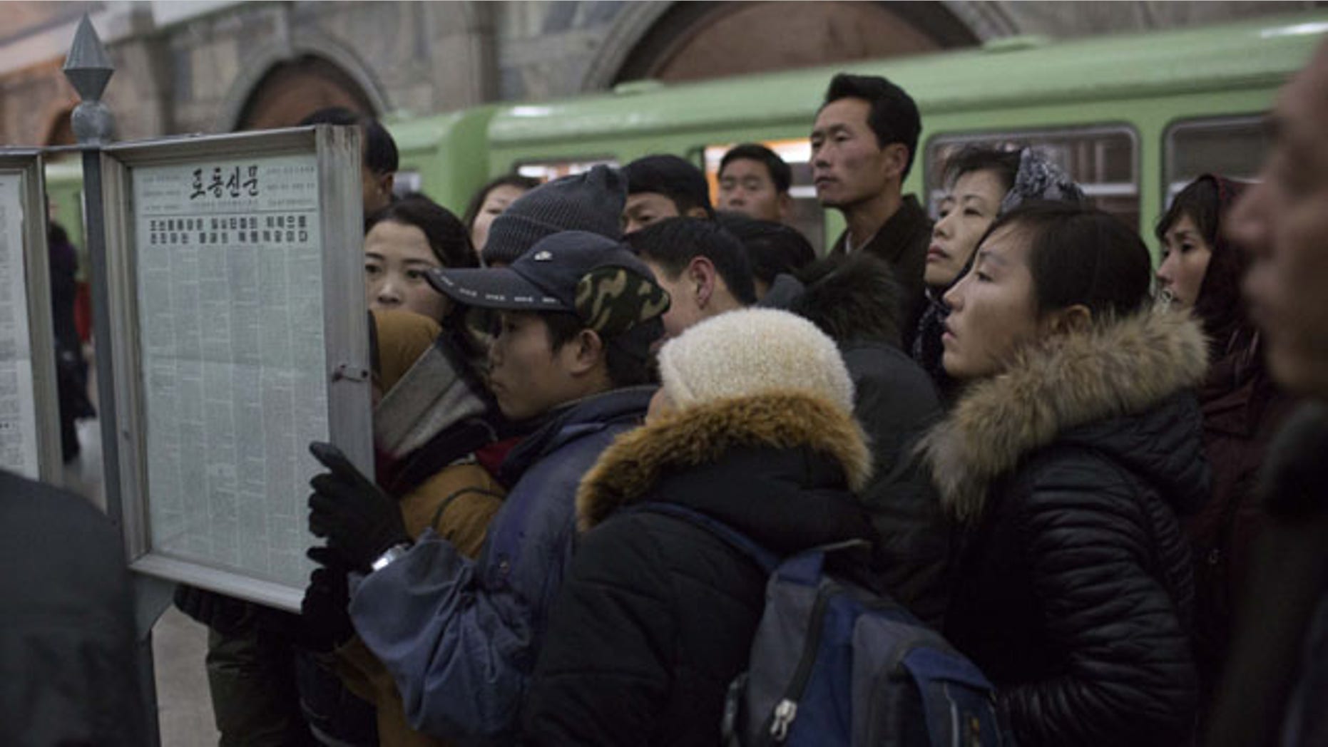 December 13, 2013: North Korean subway commuters gather around a public newspaper stand on the train platform in Pyongyang to read the headlines about Jang Song Thaek, North Korean leader Kim Jong Un's uncle who was executed as a traitor. (AP Photo/David Guttenfelder)