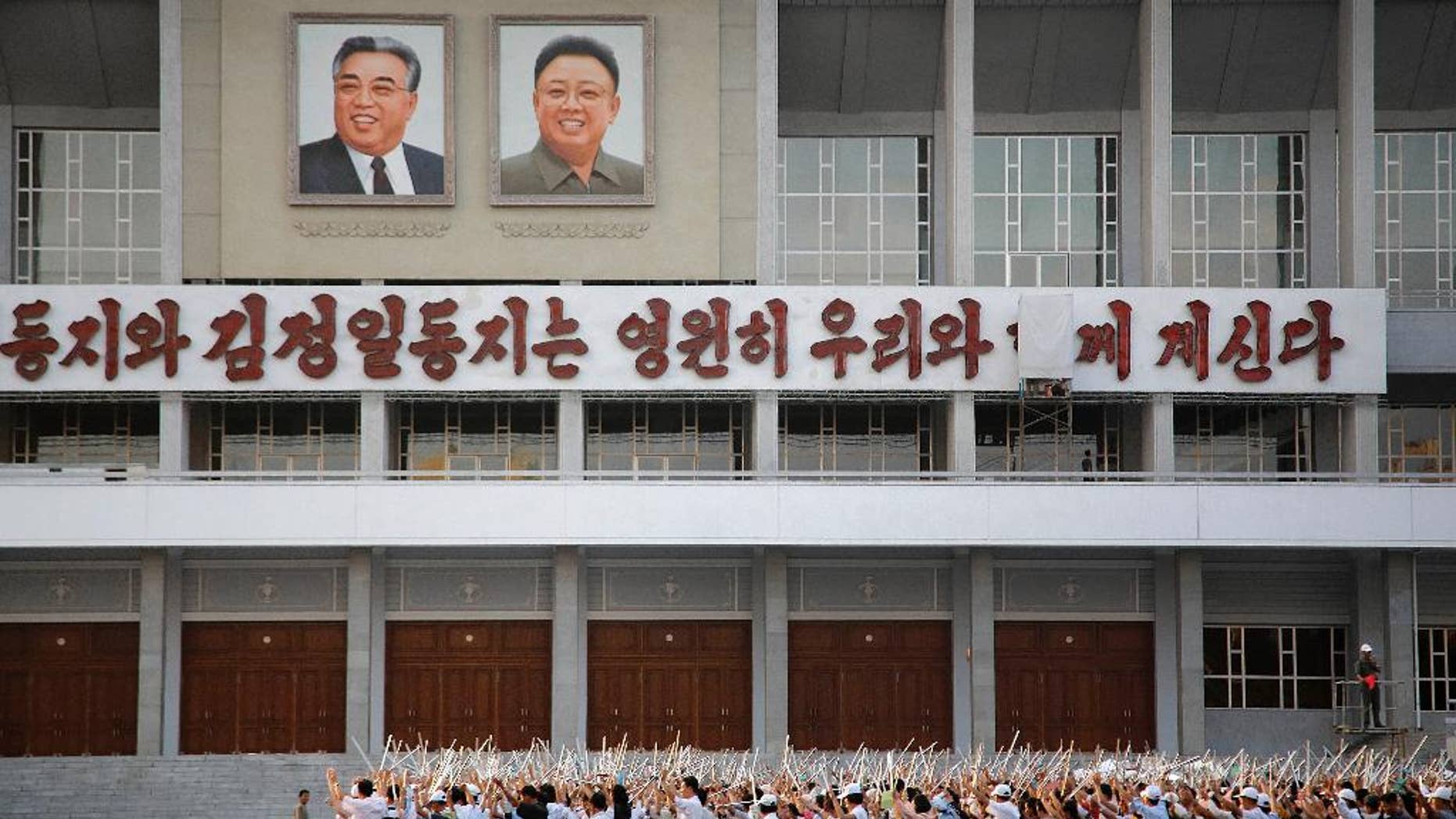 In this Tuesday, Sept. 15, 2015, photo, North Koreans gather in to prepare for events to be held during the 70th anniversary of the founding of their country's ruling party in October, in Pyongyang, North Korea. North Korea is already in high gear as it prepares to mark the 70th anniversary of the founding of its ruling party. Students and workers are being mobilized by the thousands to practice their parts in the grand show - some carrying wooden torches, others bouquets of red plastic flowers. (AP Photo/Wong Maye-E)