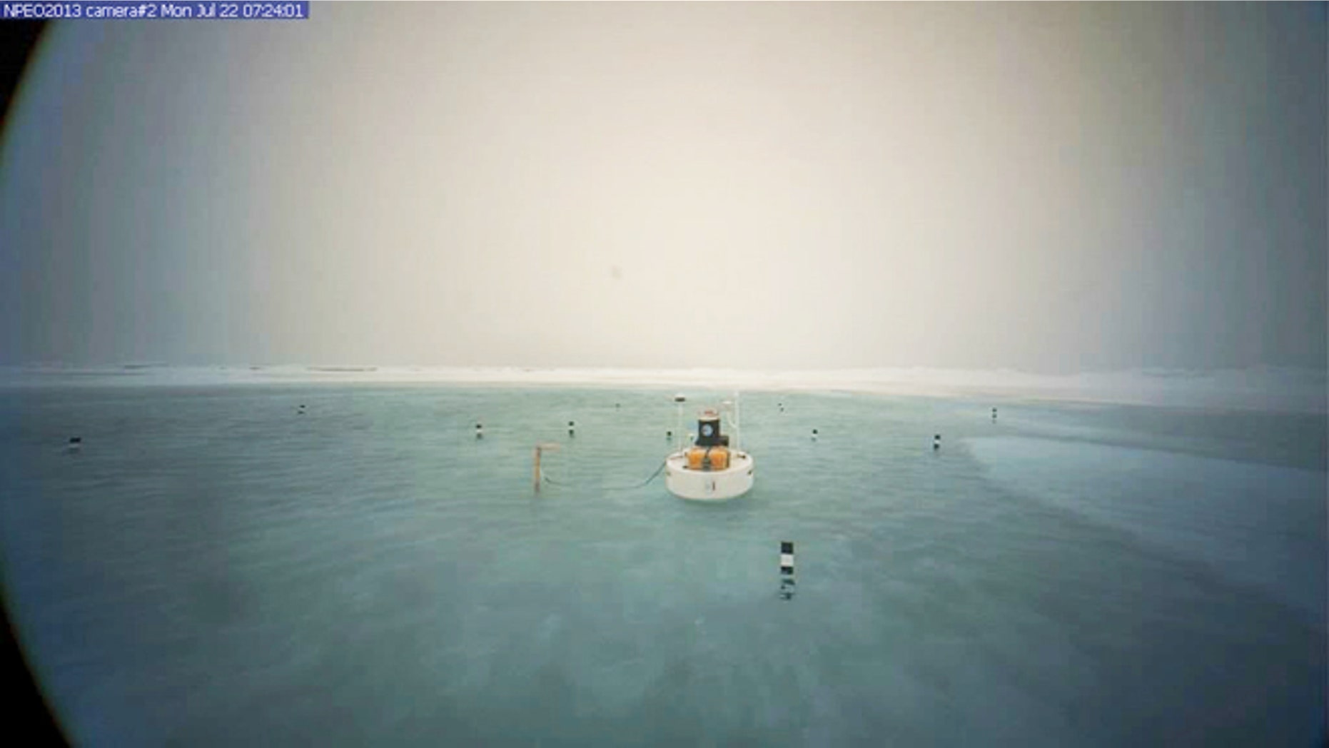 July 22, 2013: A picture of a buoy anchored near a remote webcam at the North Pole shows a meltwater lake surrounding the camera.