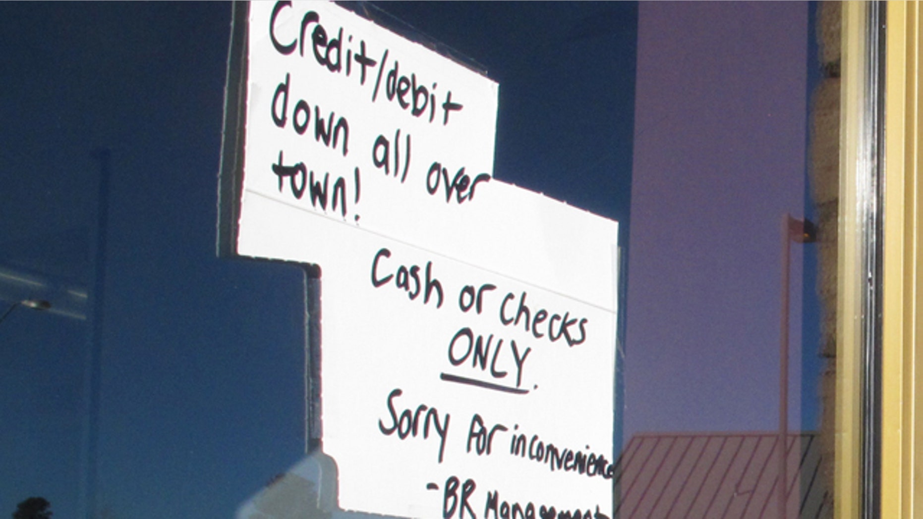 Feb. 25, 2015: A sign posted outside a Baskin-Robbins ice cream store in Flagstaff, Ariz., advises customers that only cash or checks will be accepted due to an Internet and phone outage. (AP Photo/Felicia Fonseca)