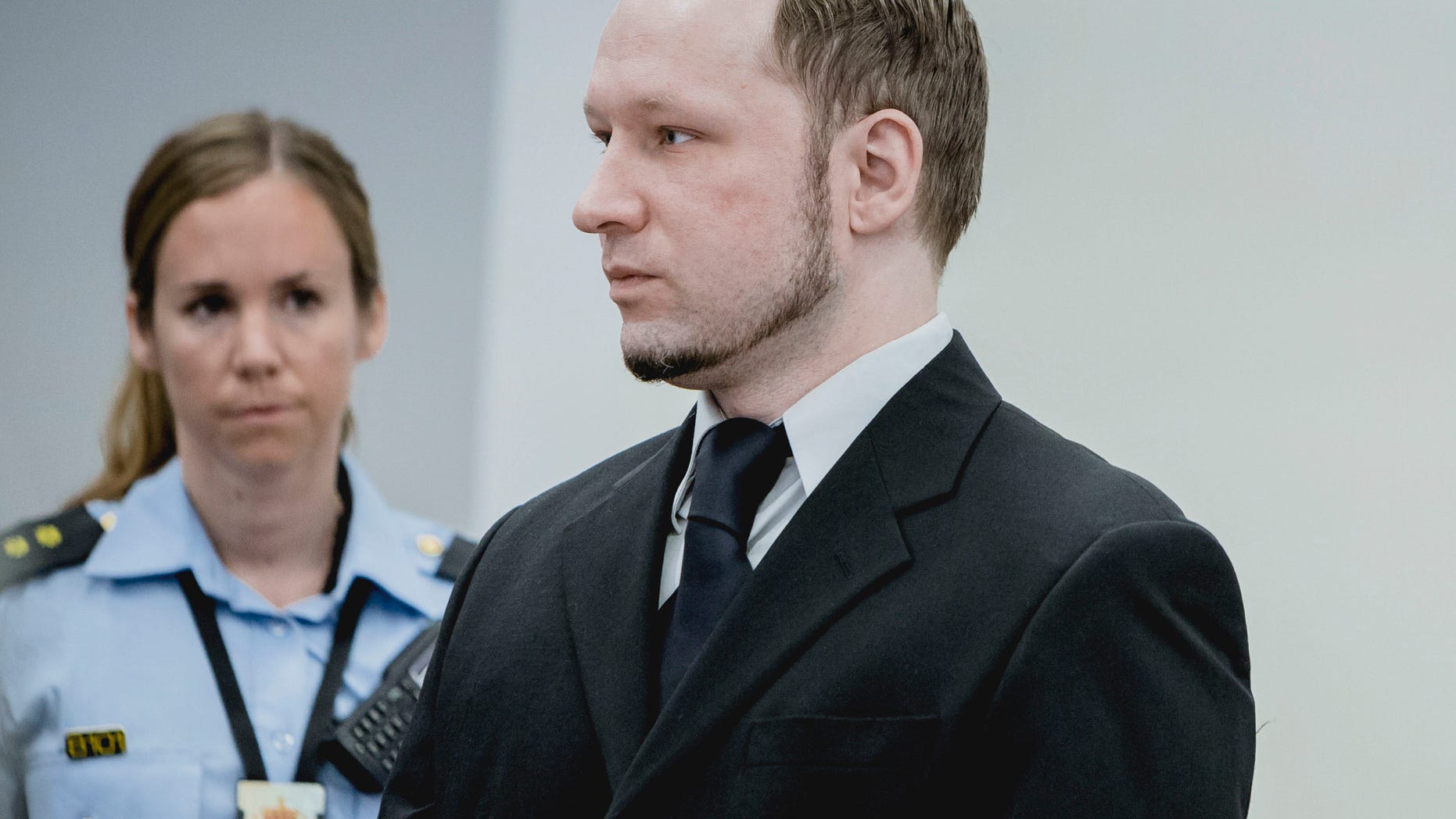 May 10, 2012: Anders Behring Breivik, who has admitted to the July 22, 2011 massacre and a bombing in Oslo that killed eight people earlier that day, stands with a police woman in court in Oslo.