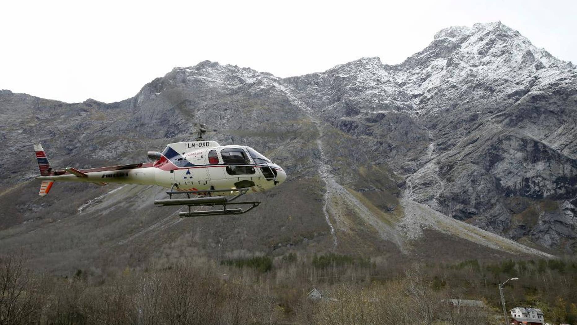 A helicopter takes off at the foot of the mountain called Mannen near Andalsnes, Norway, on Monday Oct. 27, 2014. After being on alert for weeks experts predict a huge rockslide from the mountain within days, following heavy rain in the area. (AP Photo / Terje Pedersen, NTB scanpix) NORWAY OUT