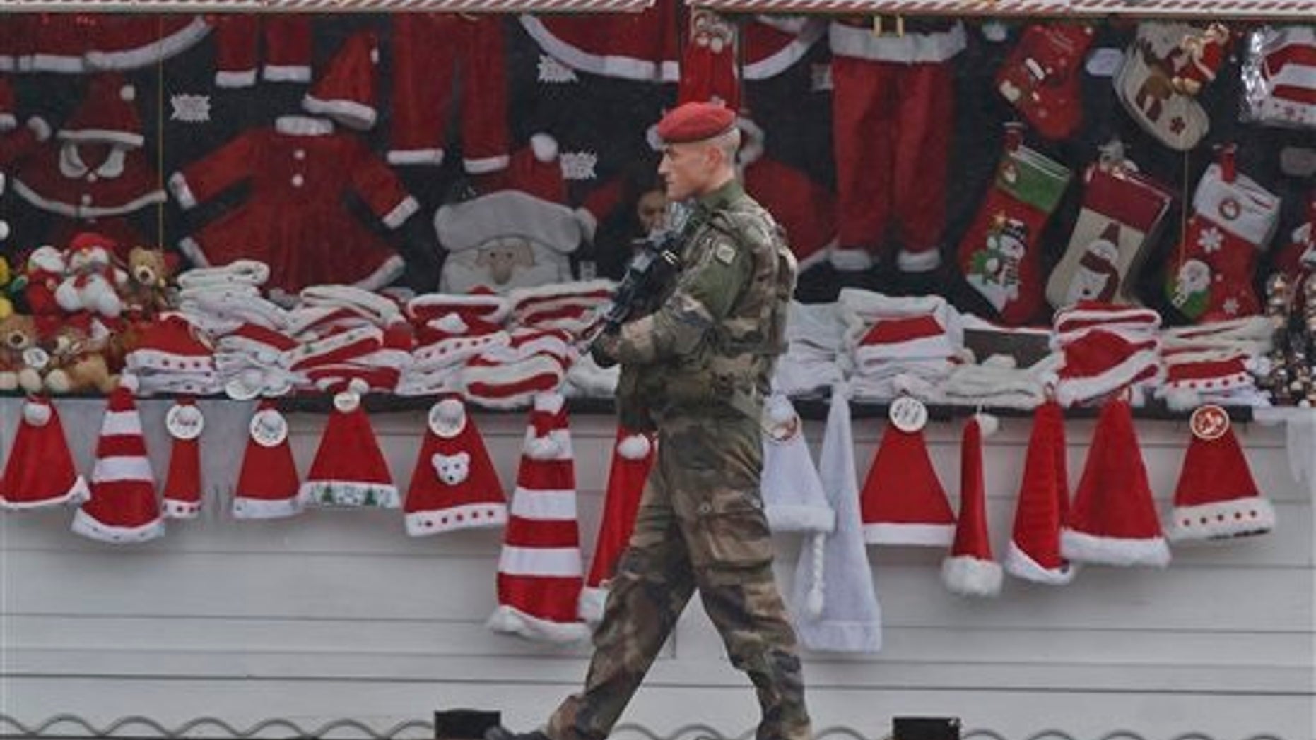 A soldiers patrols at the Christmas market along the Champs Elysees avenue in Paris, Tuesday, Nov. 24, 2015. French authorities on Tuesday questioned a top suspect linked to attackers who terrorized Paris, while Belgium's capital remained locked down under threat of a possible similar attack. (AP Photo/Michel Euler)