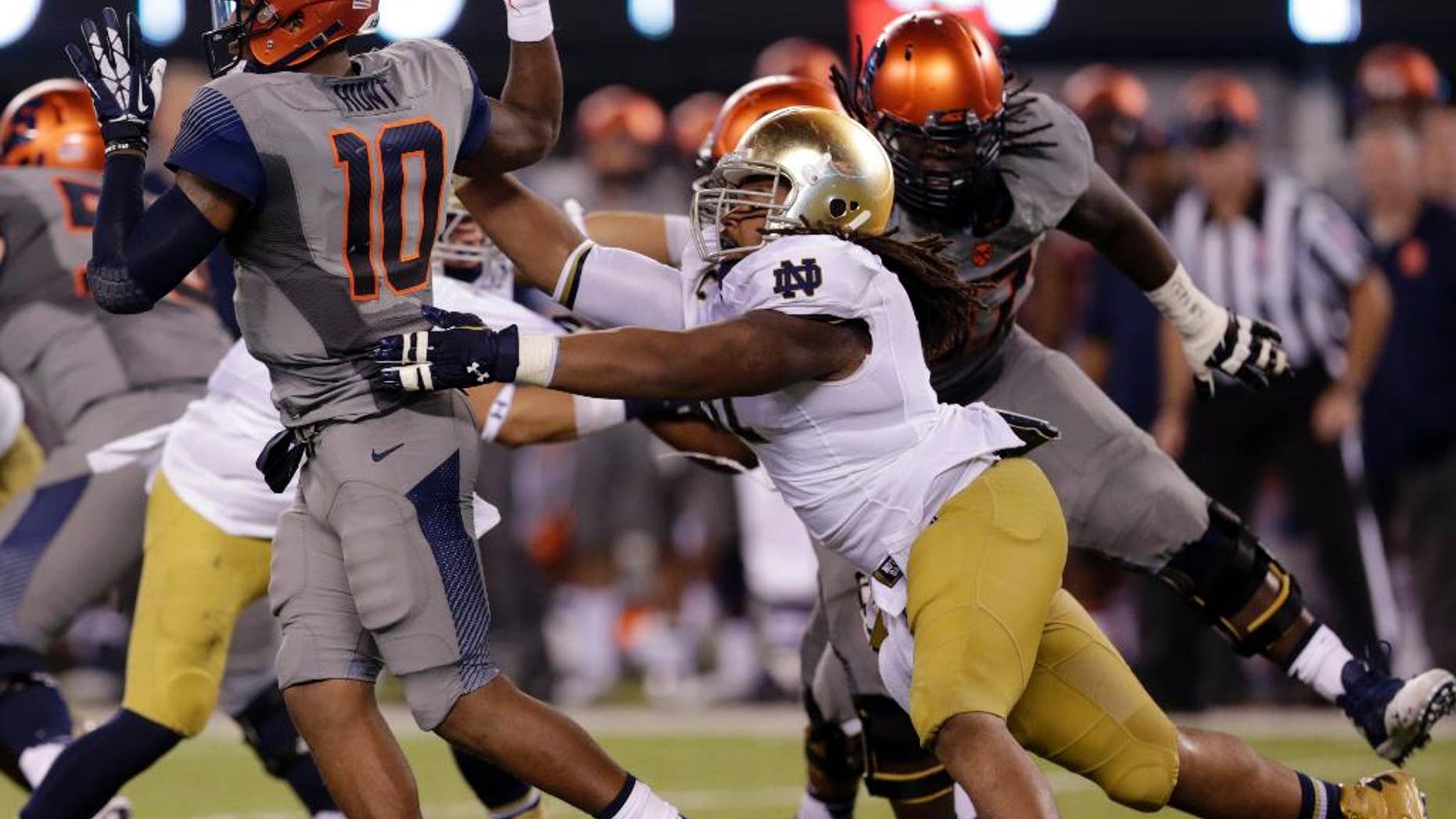 Notre Dame defensive lineman Sheldon Day, right, applies pressure on Syracuse quarterback Terrel Hunt (10) during the second half of an NCAA college football game, Saturday, Sept. 27, 2014, in East Rutherford, N.J. Notre Dame won 31-15. (AP Photo/Julio Cortez)