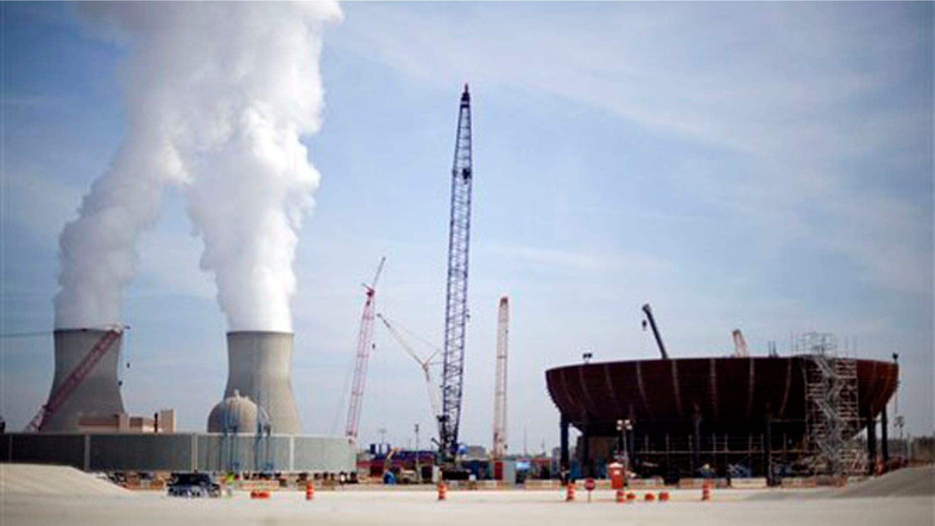 Feb. 15, 2012: In this file photo, cooling towers for units 1 and 2 are seen at left as the new reactor vessel bottom head for unit 3 stands under construction at right at the Vogtle nuclear power plant in Waynesboro, Ga.