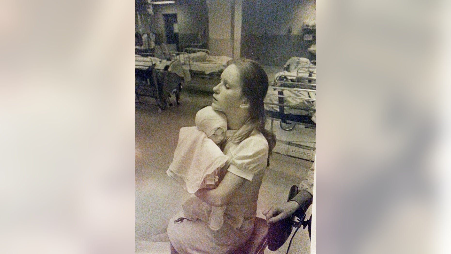 In this 1977 photo provided by Albany Medical Center, nurse Susan Berger cuddles infant Amanda Scarpinati, who had been severely burned by a steam vaporizer at home, in the pediatric unit at Albany Medical Center in Albany N.Y.
