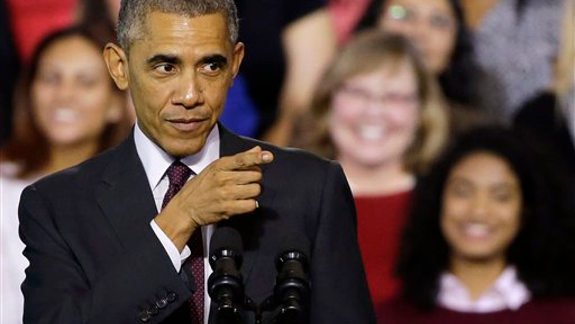President Barack Obama gestures toward the crowd after participating in a roundtable discussion with working parents, small business owners, students and faculty, Friday, Oct. 31, 2014, at Rhode Island College in Providence, R.I. (AP Photo/Stephan Savoia)
