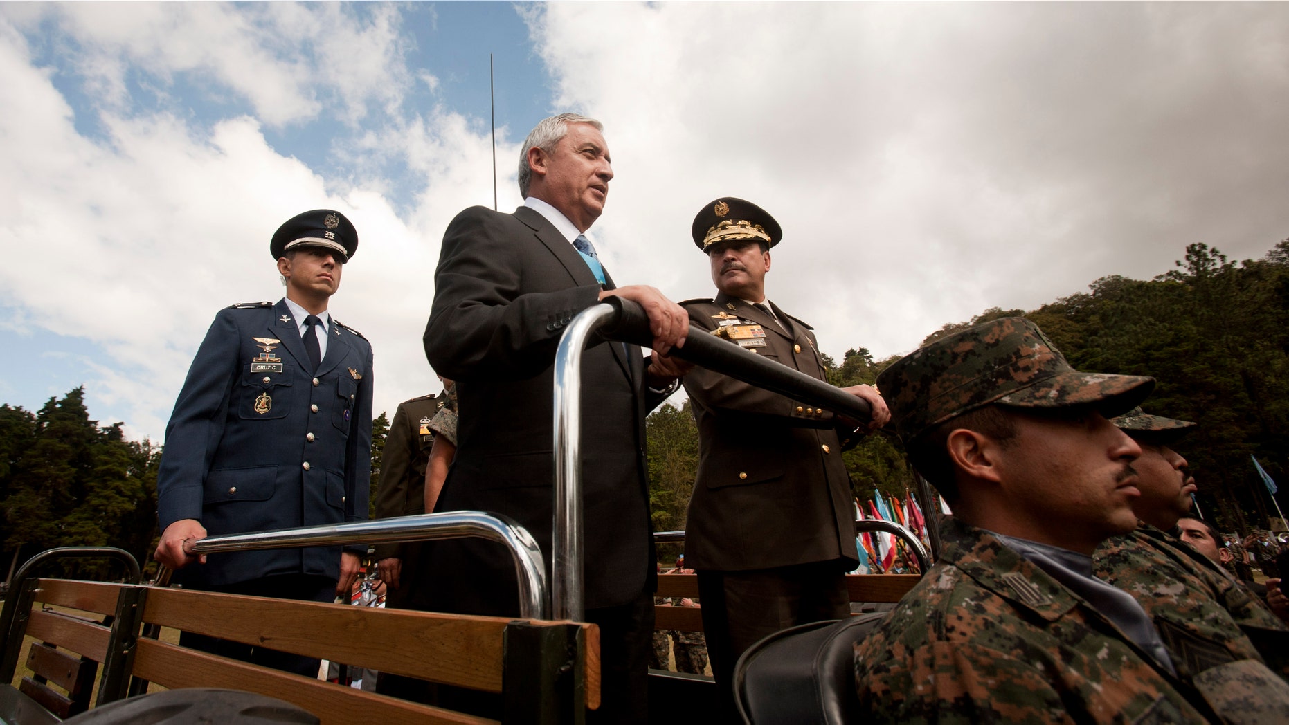 Guatemala's newly sworn-in President Otto Perez Molina, center, and Minister of Defense Ulises Anzueto Giron, right, review the troops during a military ceremony recognizing Perez as commander-in-chief, in Guatemala City, Sunday Jan. 15, 2012. Perez, a retired general, is the first military officer elected as Guatemalan president since the end of a military government 25 years ago. He served in that administration as director of intelligence. (AP Photo/Moises Castillo)