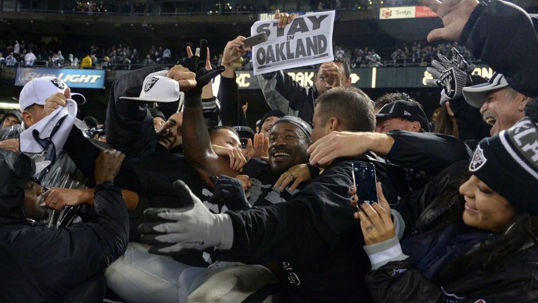 Nov 20, 2014; Oakland, CA, USA; Oakland Raiders lineabcker Sio Moore (55) celebrates with fans after the game against the Kansas City Chiefs at O.co Coliseum. The Raiders defeated the Chiefs 24-20. Mandatory Credit: Kirby Lee-USA TODAY Sports