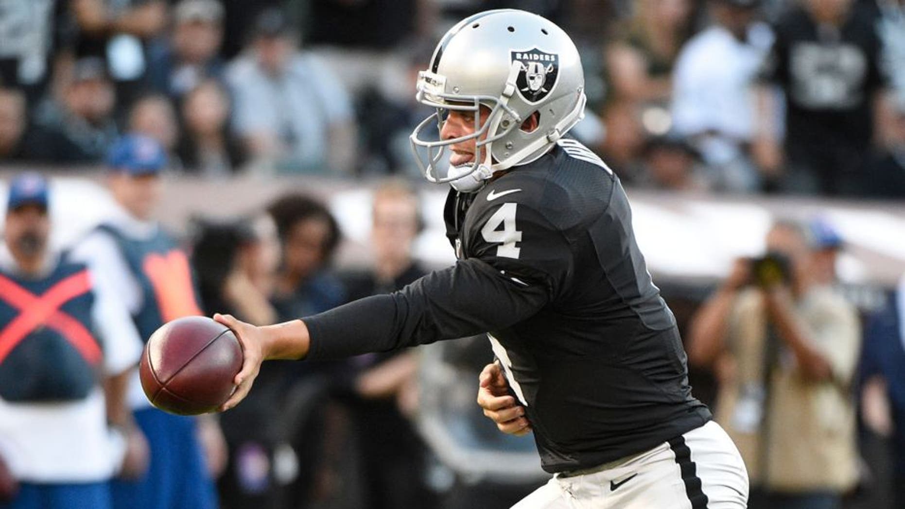 August 14, 2015; Oakland, CA, USA; Oakland Raiders quarterback Derek Carr (4) hands the football off against the St. Louis Rams during the first quarter in a preseason NFL football game at O.co Coliseum. Mandatory Credit: Kyle Terada-USA TODAY Sports
