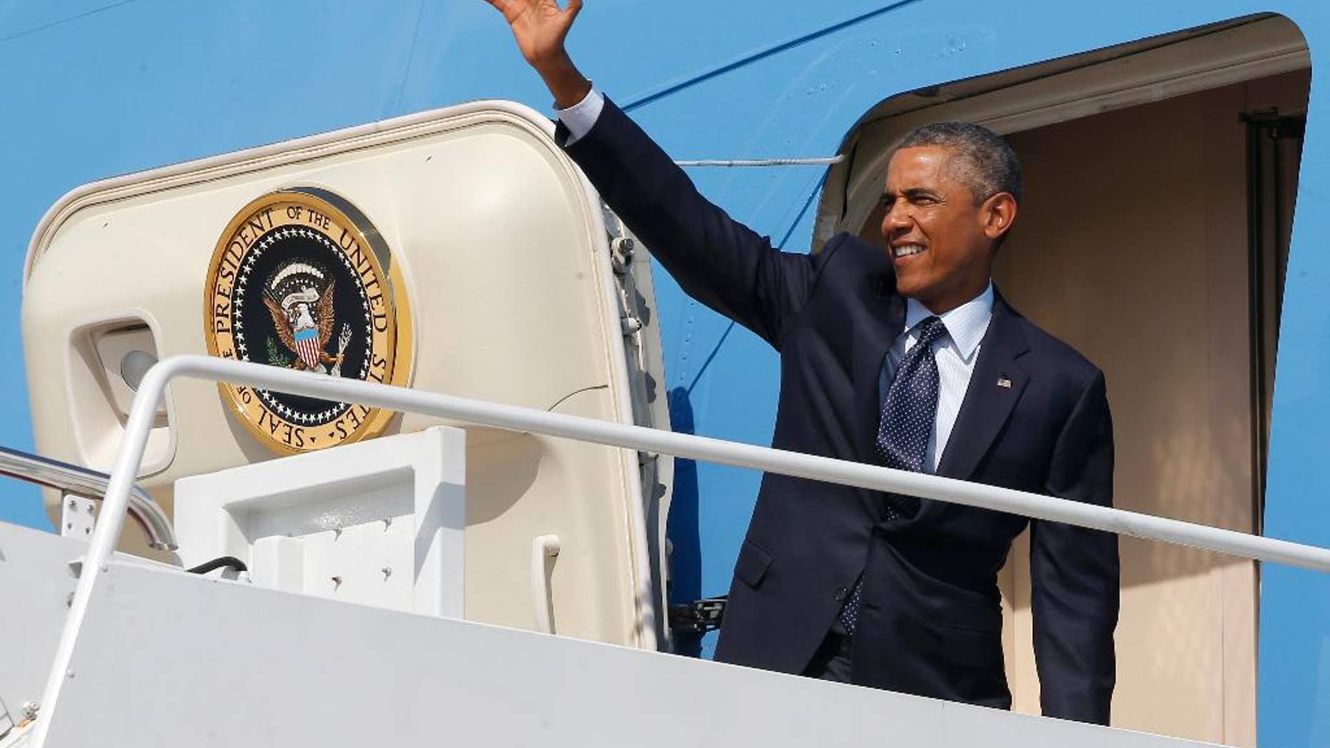President Barack Obama waves as he boards Air Force One at Andrews Air Force Base, Md., Tuesday, Sept. 2, 2014, as he begins his trip to Estonia and Wales for the NATO Summit. (AP Photo/Charles Dharapak)