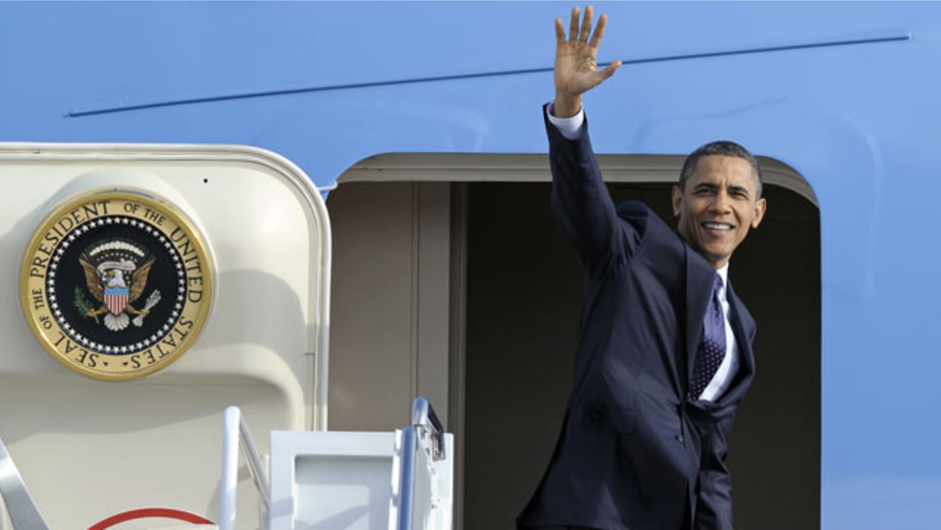 December 23, 2011: President Barack Obama waves as he boards Air Force One at Andrews Air Force Base, Md.