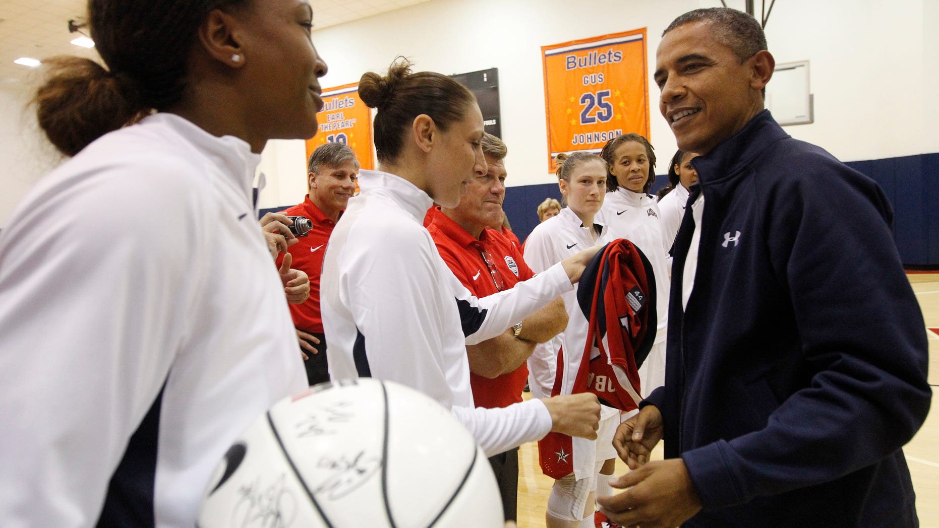 July 16, 2012: President Barack Obama, right, meets with Team USA's Tamika Catchings, left, and Diana Taurasi, center, and other members of the Olympic women's basketball following their exhibition game against Brazil in Washington.