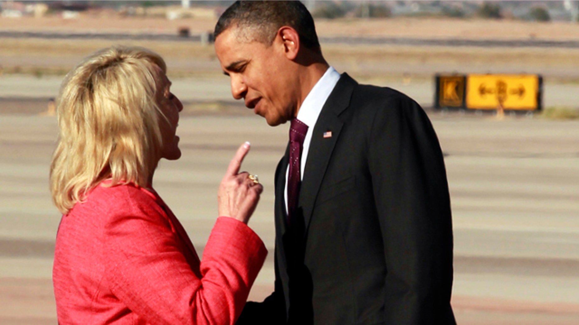 Jan. 25, 2012: Arizona Gov. Jan Brewer points at President Obama after he arrived at Phoenix-Mesa Gateway Airport.