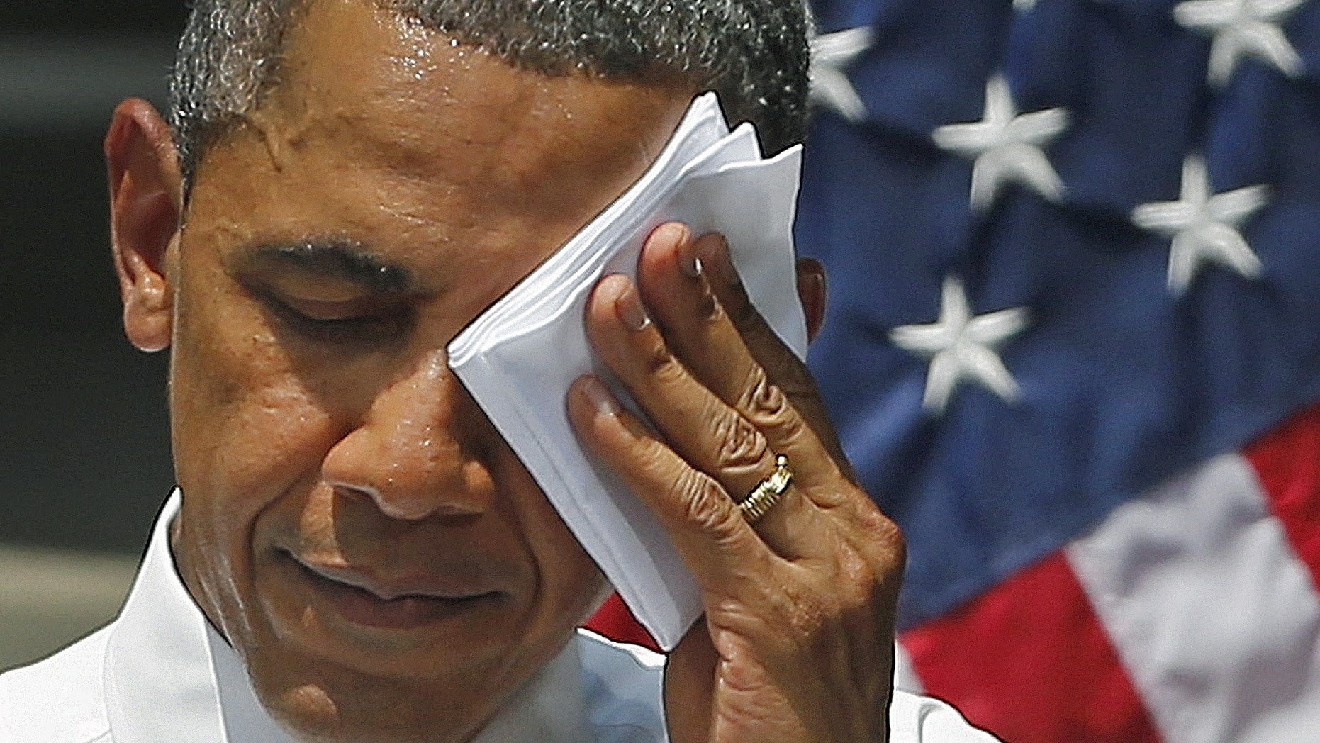 FILE -- June 25, 2013: President Obama wipes his face as he speaks about climate change, Tuesday, June 25, 2013, at Georgetown University in Washington.