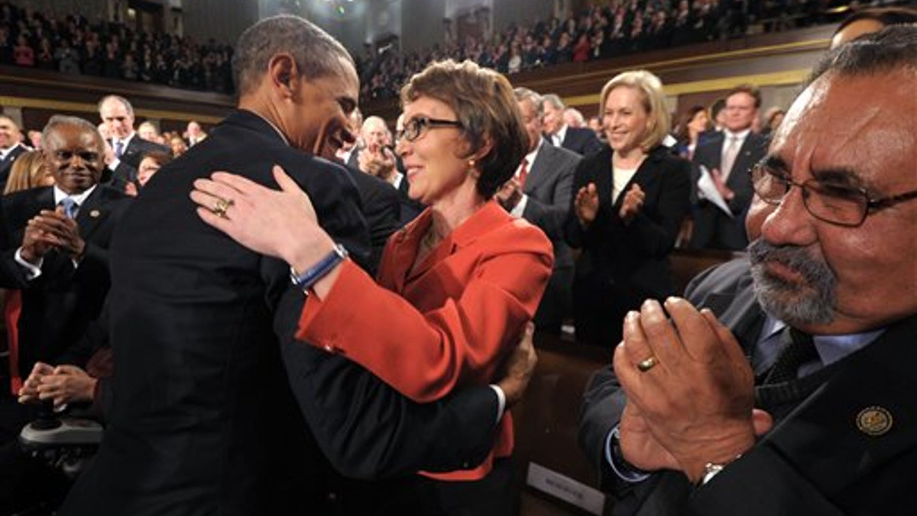 Jan. 24, 2012: President Obama embraces retiring Rep. Gabrielle Giffords, D-Ariz., as members of Congress applaud before his State of the Union address.