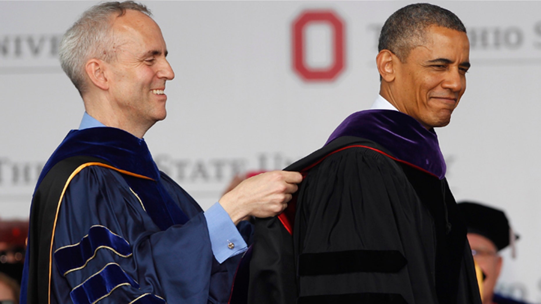 COLUMBUS, OH - MAY 05: Ohio State Trustee David Horn (L) puts a sash on U.S. President Barack Obama during commencement ceremonies at The Ohio State University at Ohio Stadium on May 5, 2013 in Columbus, Ohio. Obama addressed the graduates a year from the day he kicked off his re-election campaign at the campus.The president was also given an honorary degree Doctor of Laws. (Photo by Matt Sullivan/Getty Images)