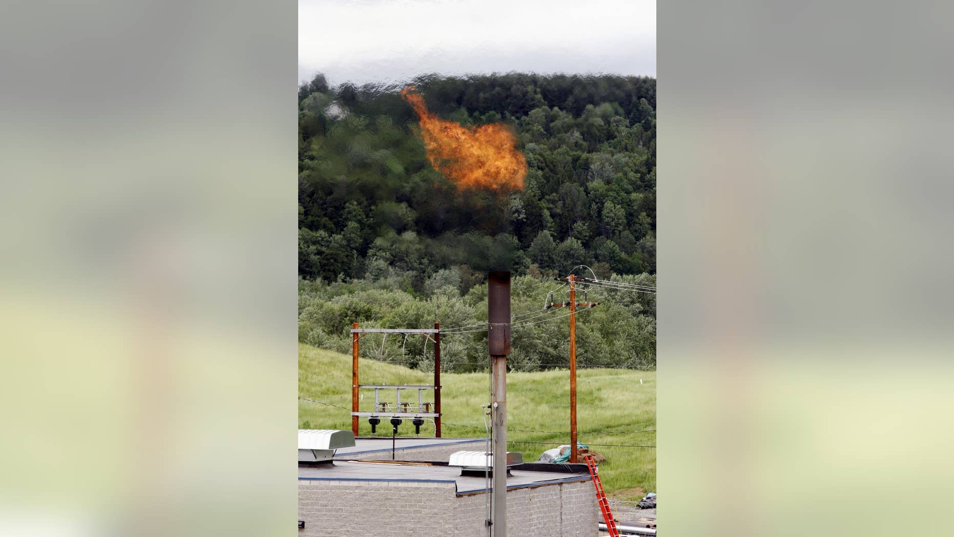 FILE - In this June 15, 2005 photo, methane gas burns off a stack near the Washington Electric Cooperative power plant in Coventry, Vt. The Obama administration is proposing to cut methane emissions from U.S. oil and gas production by nearly half over the next decade in an unprecedented step to curb climate change. (AP Photo/Toby Talbot, File)