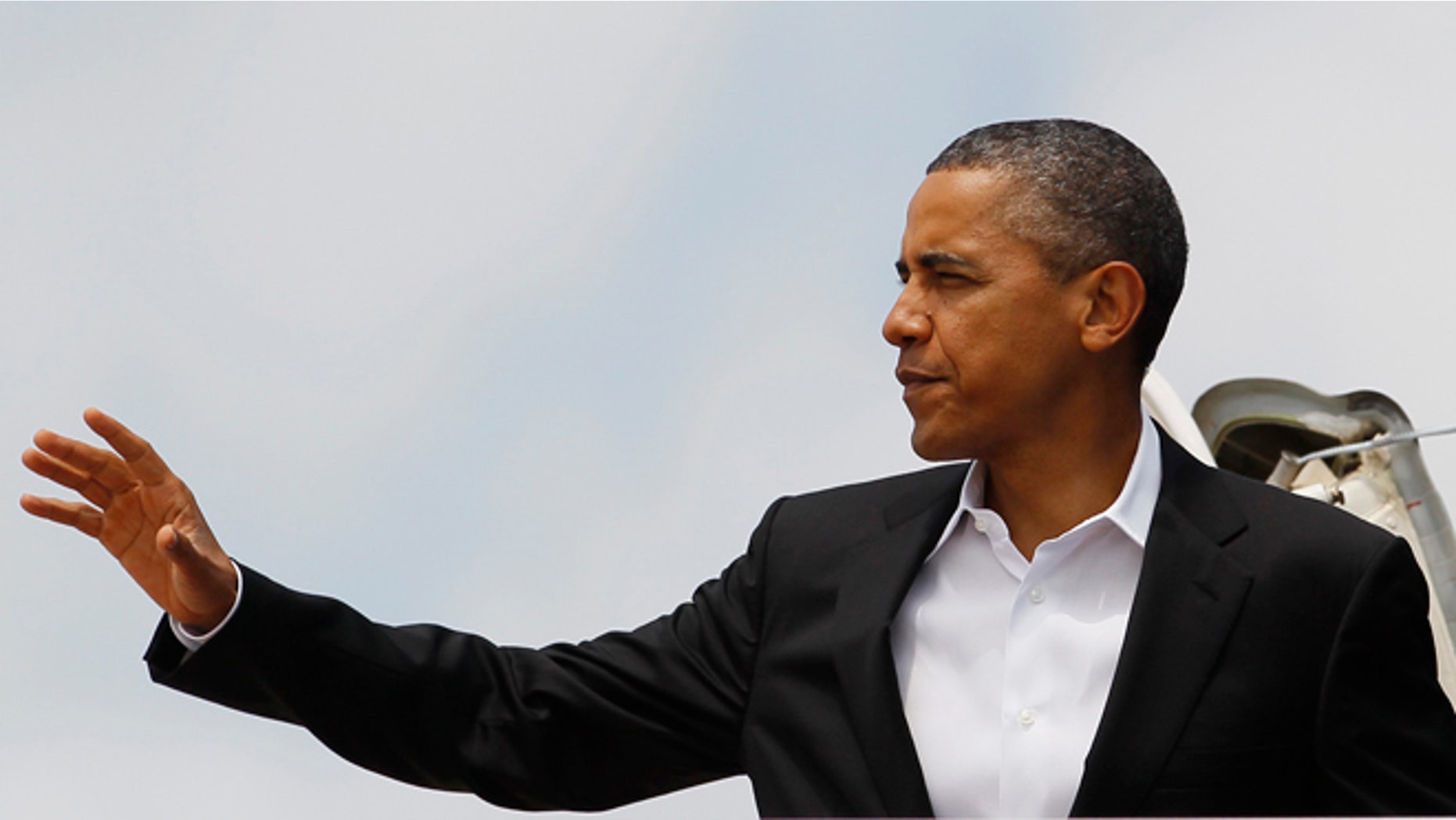 President Barack Obama moves to wave as he boards Air Force One, Saturday, Aug. 11, 2012, in Andrews Air Force Base, Md., en route to Chicago. (AP Photo/Carolyn Kaster)