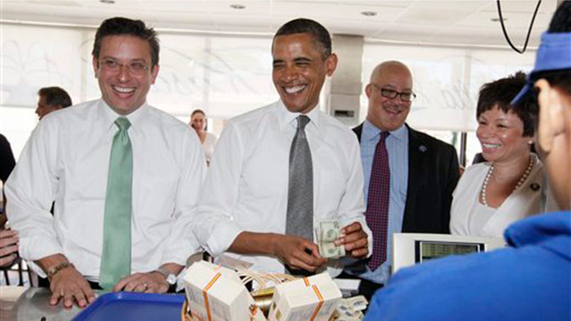 El presidente Barack Obama, de visita en la capital de Puerto Rico, ordena algo para almorzar en un restaurante el martes 14 de junio del 2011. Le acompañan el senador Alejandro GarcÃa Padilla, izquierda, y una de las asesoras del mandatario, Valerie Jarrett, derecha. (Foto AP/Carolyn Kaster)