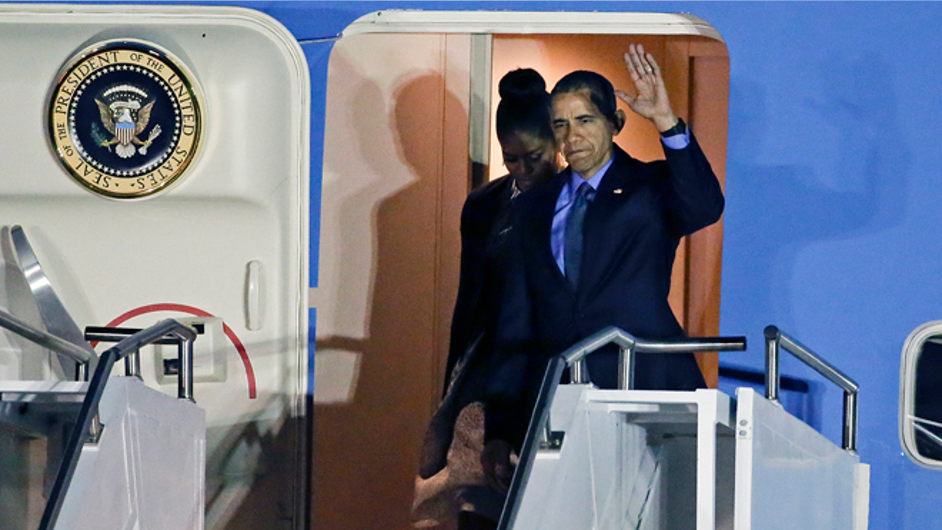 President Barack Obama, right, and first lady Michelle Obama, arrive at San Bernardino International Airport, on Friday, Dec. 18, 2015, in San Bernardino, Calif. Obama is meeting with families of the victims of a mass shooting that struck the community. (AP Photo/Chris Carlson)