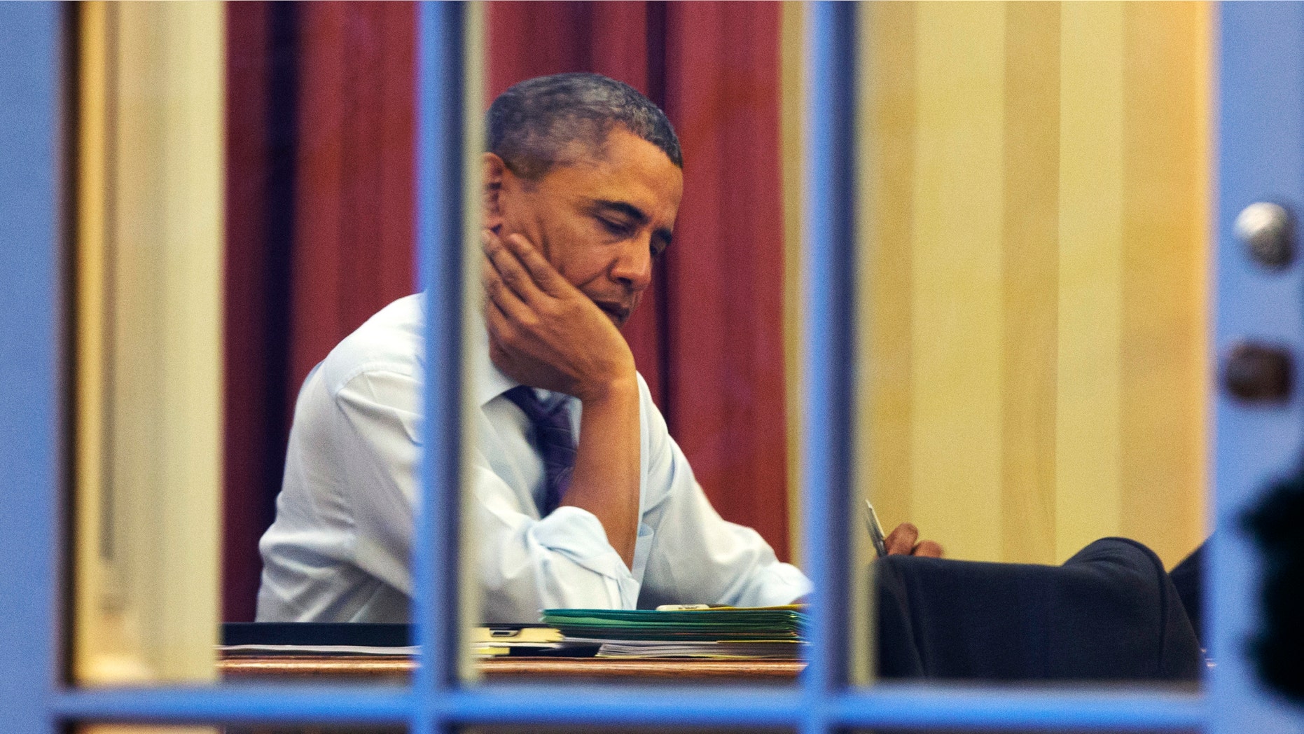 President Barack Obama works at his desk in the Oval Office of the White House in Washington, Monday, Jan. 27, 2014, ahead of Tuesday night's State of the Union speech. (AP Photo/Jacquelyn Martin)