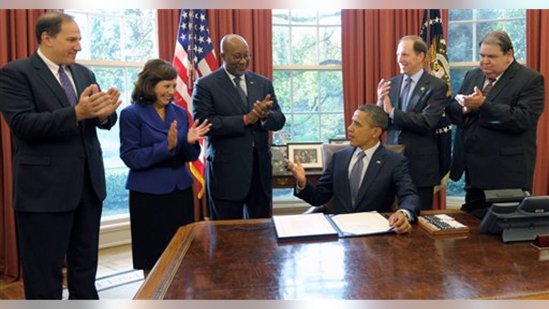 October 21: President Barack Obama speaks in the Oval Office of the White House. From left are, Deputy Labor Secretary Seth Harris, Labor Secretary Hilda Solis, US Trade Representative Ron Kirk, Rep. Dave Camp, R-Mich., and United Steelworkers Vice President Thomas Conway.