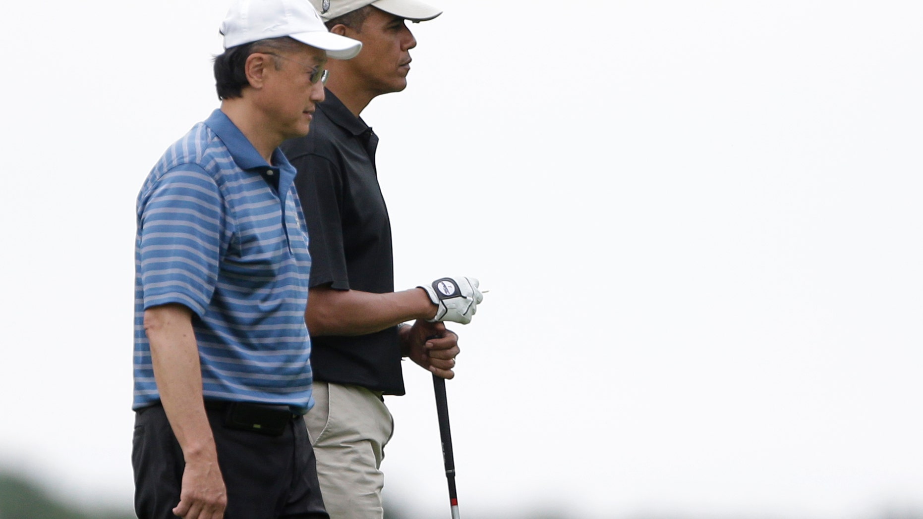 President Barack Obama, right, stands with World Bank President Jim Kim, left, while golfing at Vineyard Golf Club in Edgartown, Mass., on the island of Martha's Vineyard Sunday, Aug. 18, 2013. Obama returned to the golf course Sunday to play his sixth and final round of a weeklong vacation on Martha's Vineyard. (AP Photo/Steven Senne)